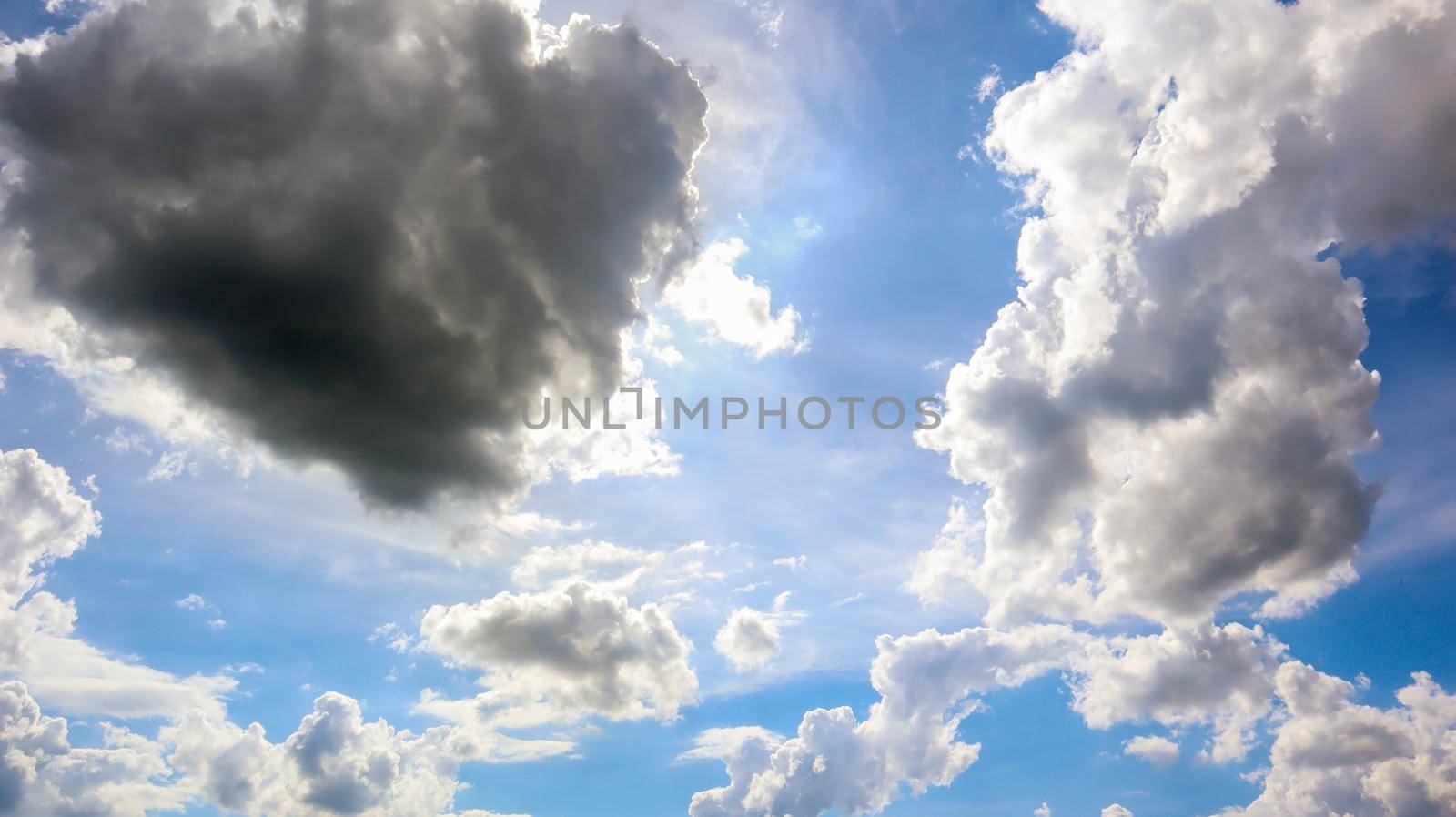 Blue sky with white plump fluffy clouds and sun. Cumulus clouds. Nature weather blue sky. Beautiful background white clouds