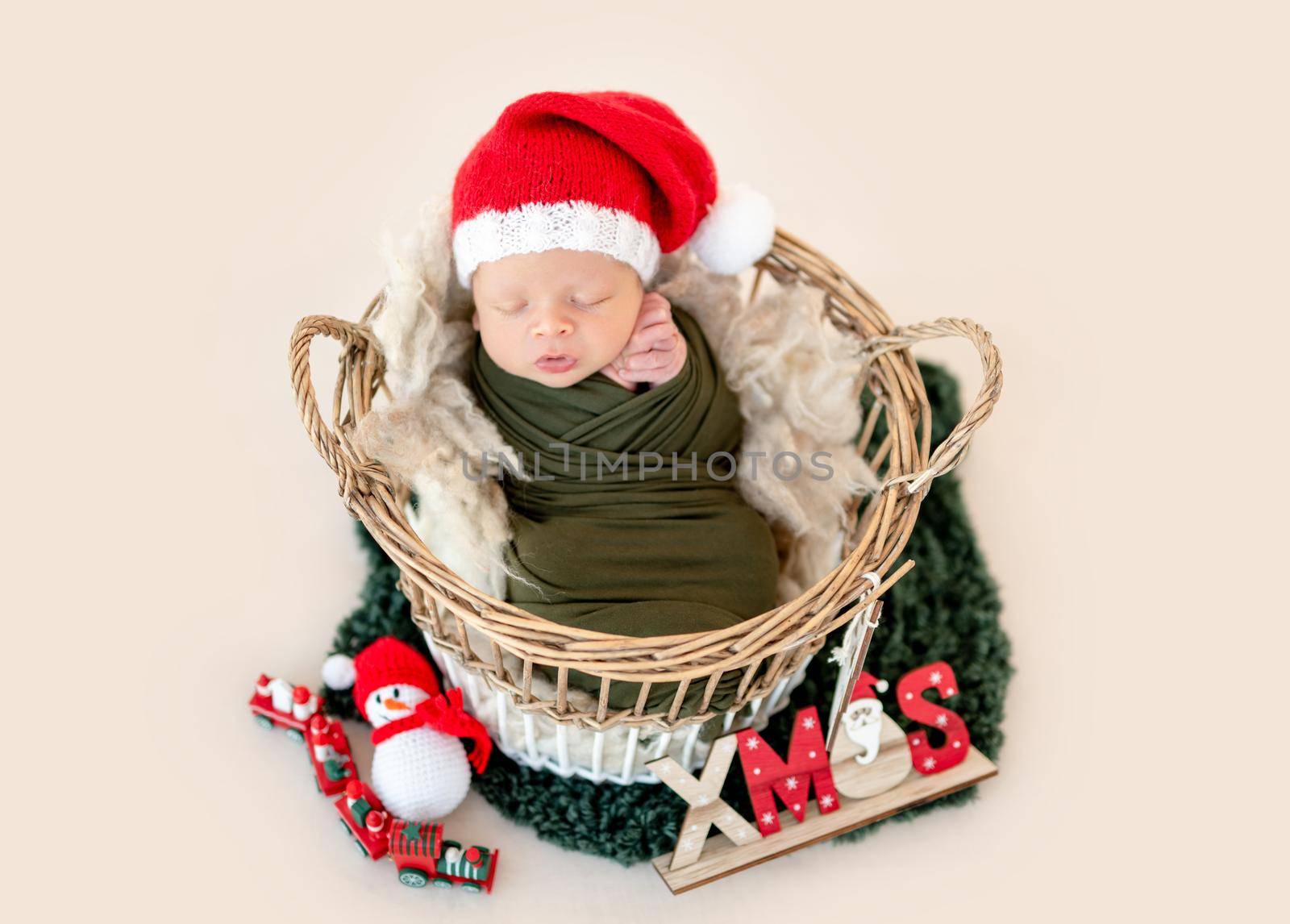 Adorable newborn in christmas hat sleeping in basket