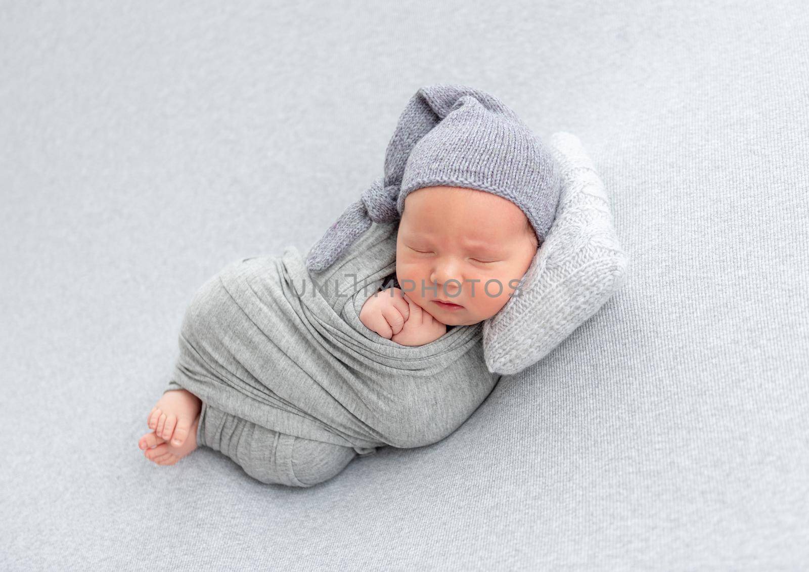 Adorable newborn resting on tiny pillow