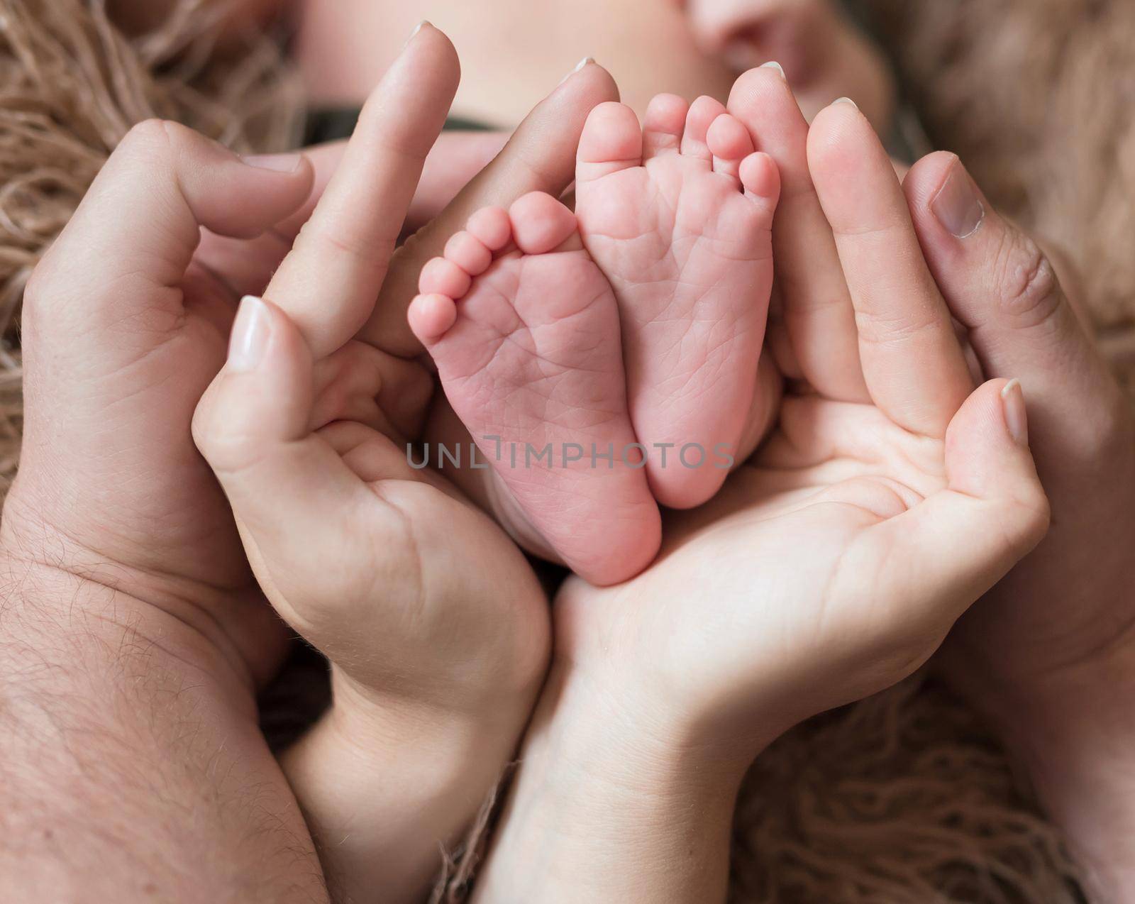 Parents holding little baby's legs by tan4ikk1