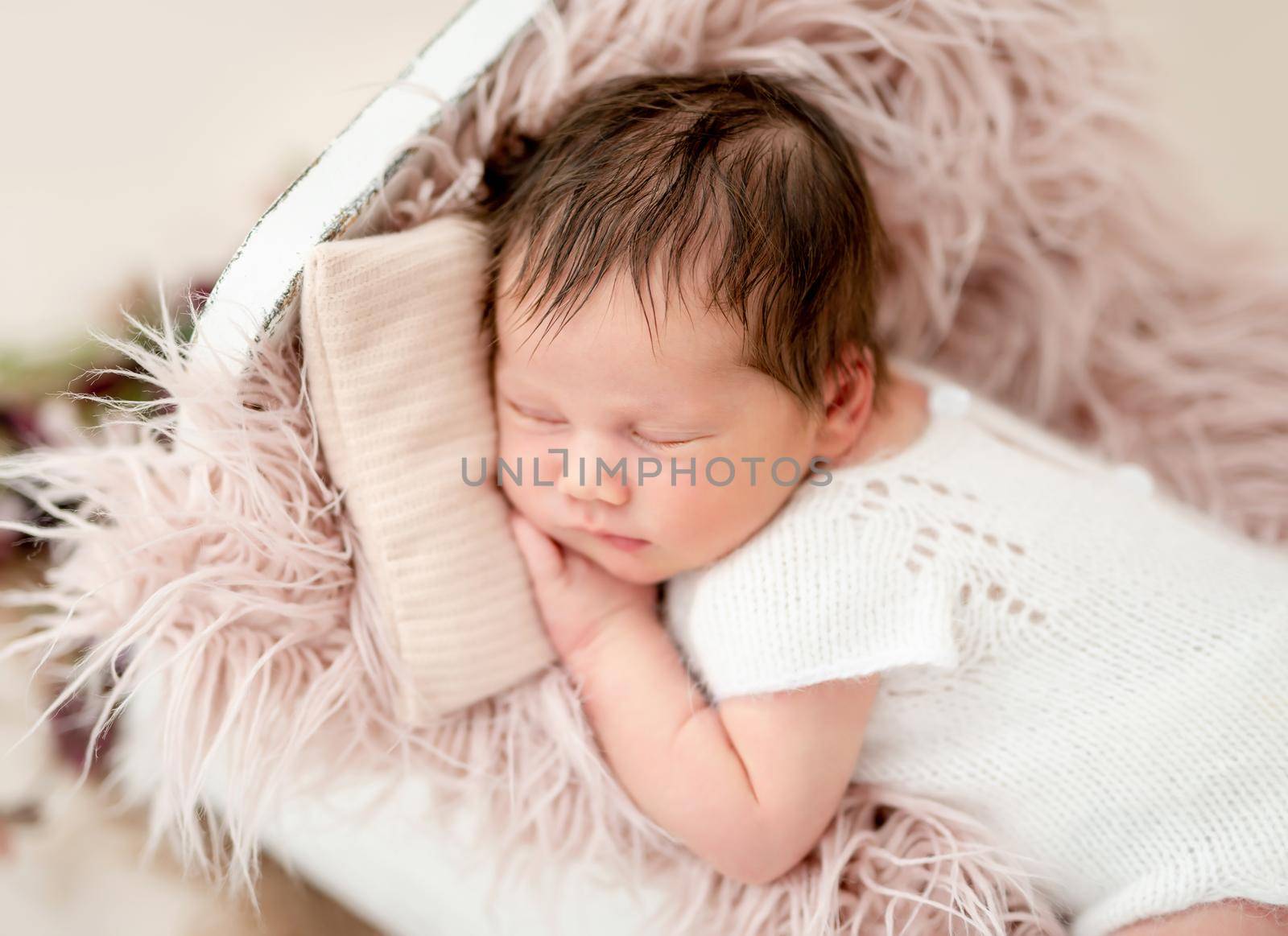 Charming newborn sleeping in tiny bed