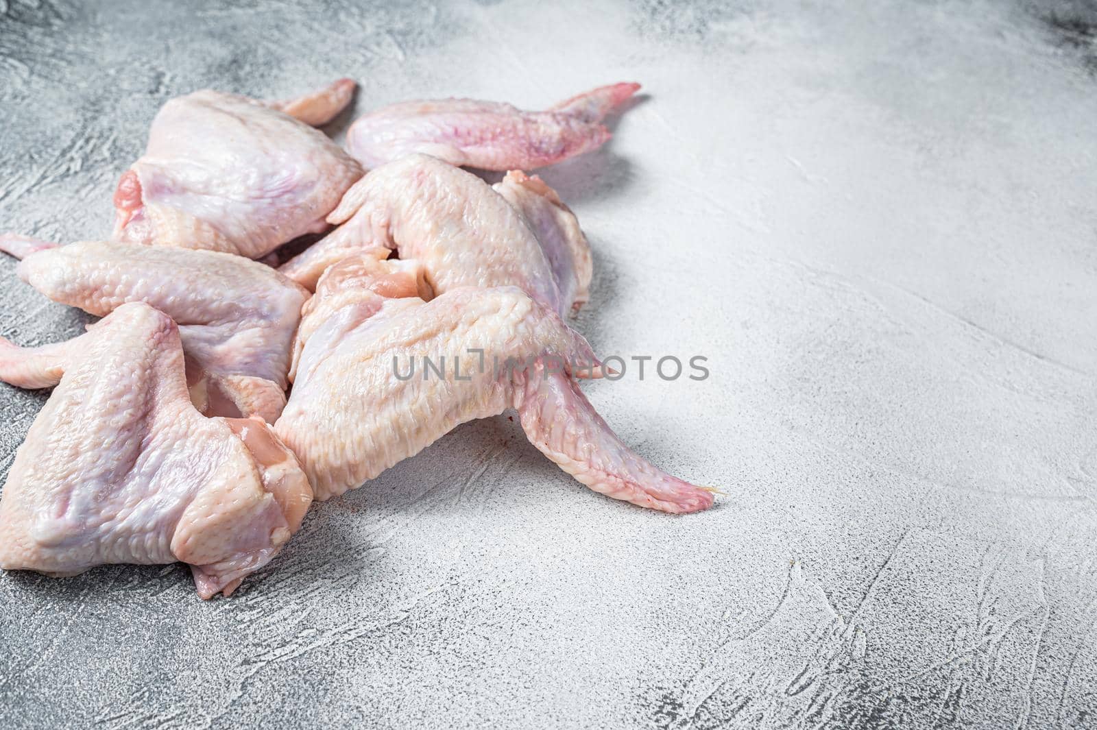 Raw chicken wings on a kitchen table. White background. Top view. Copy space.