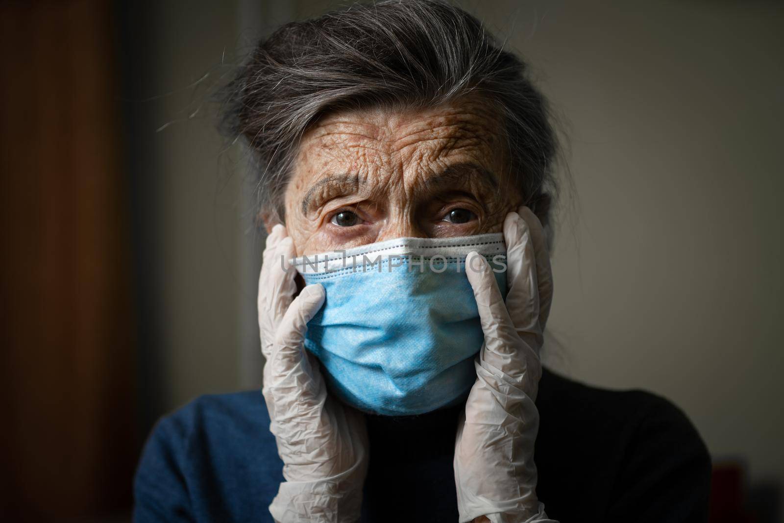 Sad senior woman in protective mask, latex gloves at home during coronavirus pandemic. Stay at home. Old granny retired quarantined epidemic covid 19. Gray hair female in mask infection, bacteria flu by Tomashevska