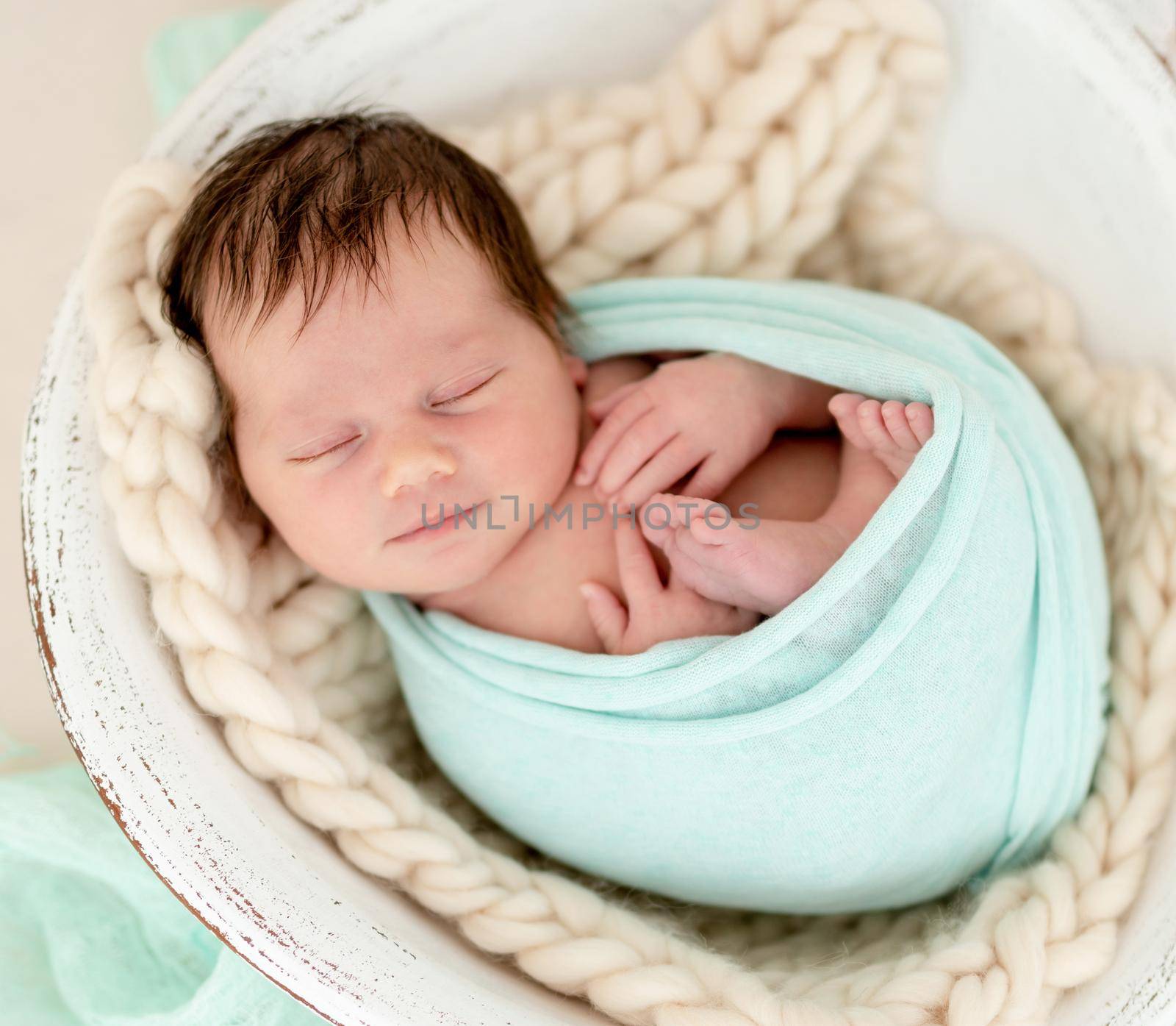 Smiling newborn girl sleeping in cradle