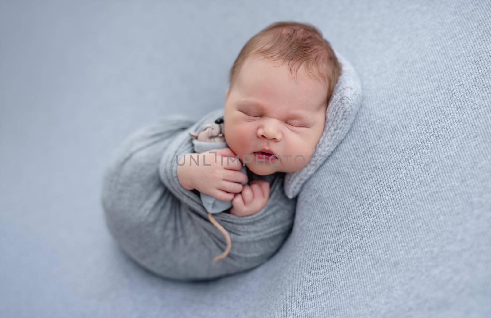 Beautiful sleeping newborn with toy in tiny hands