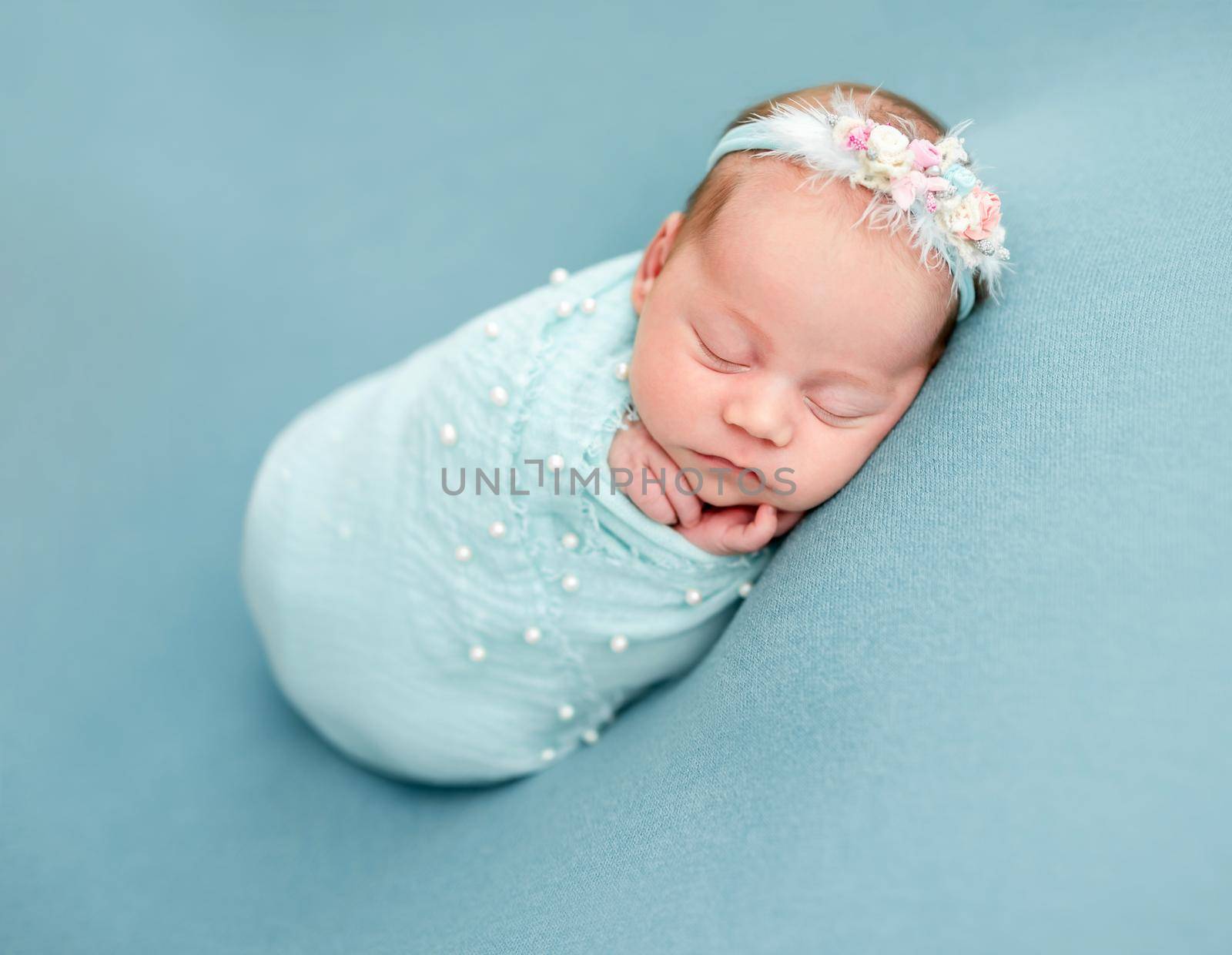 Adorable newborn wrapped in blue blanket
