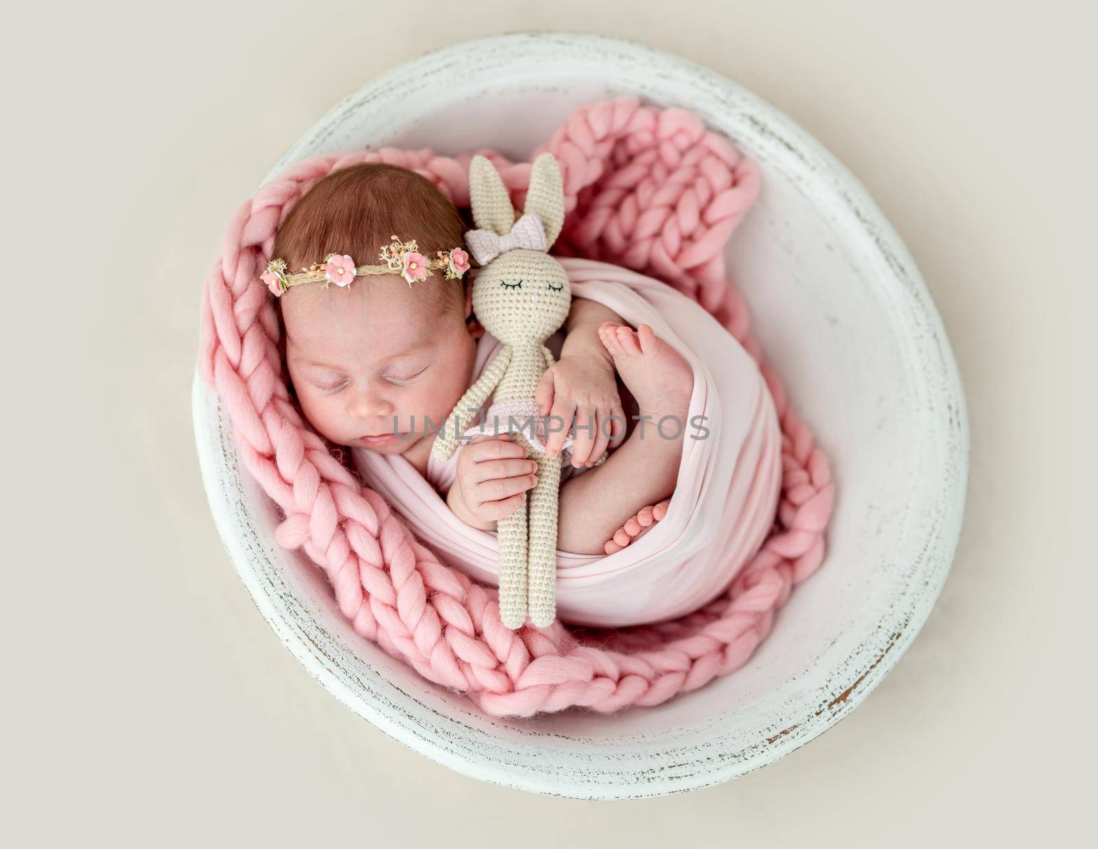 Lovely newborn sleeping with knitted toy