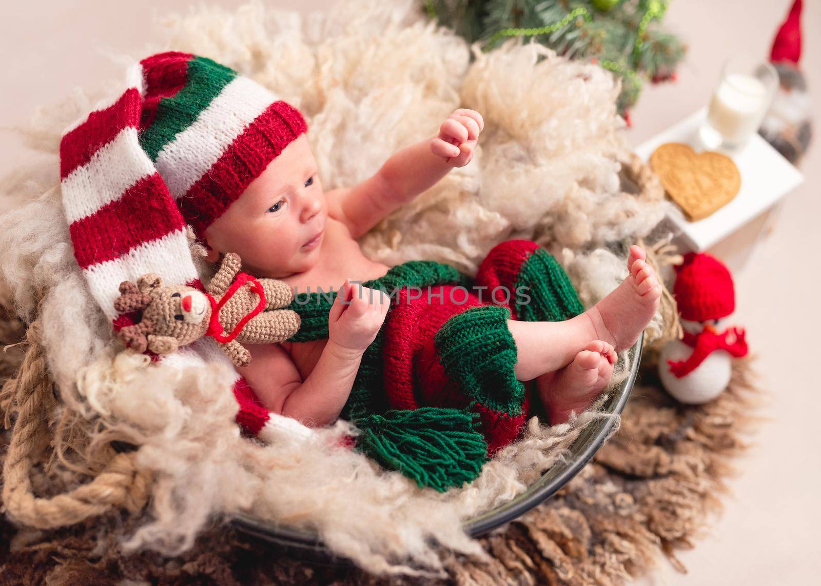 Top view of baby in knitted suit with new year decortions