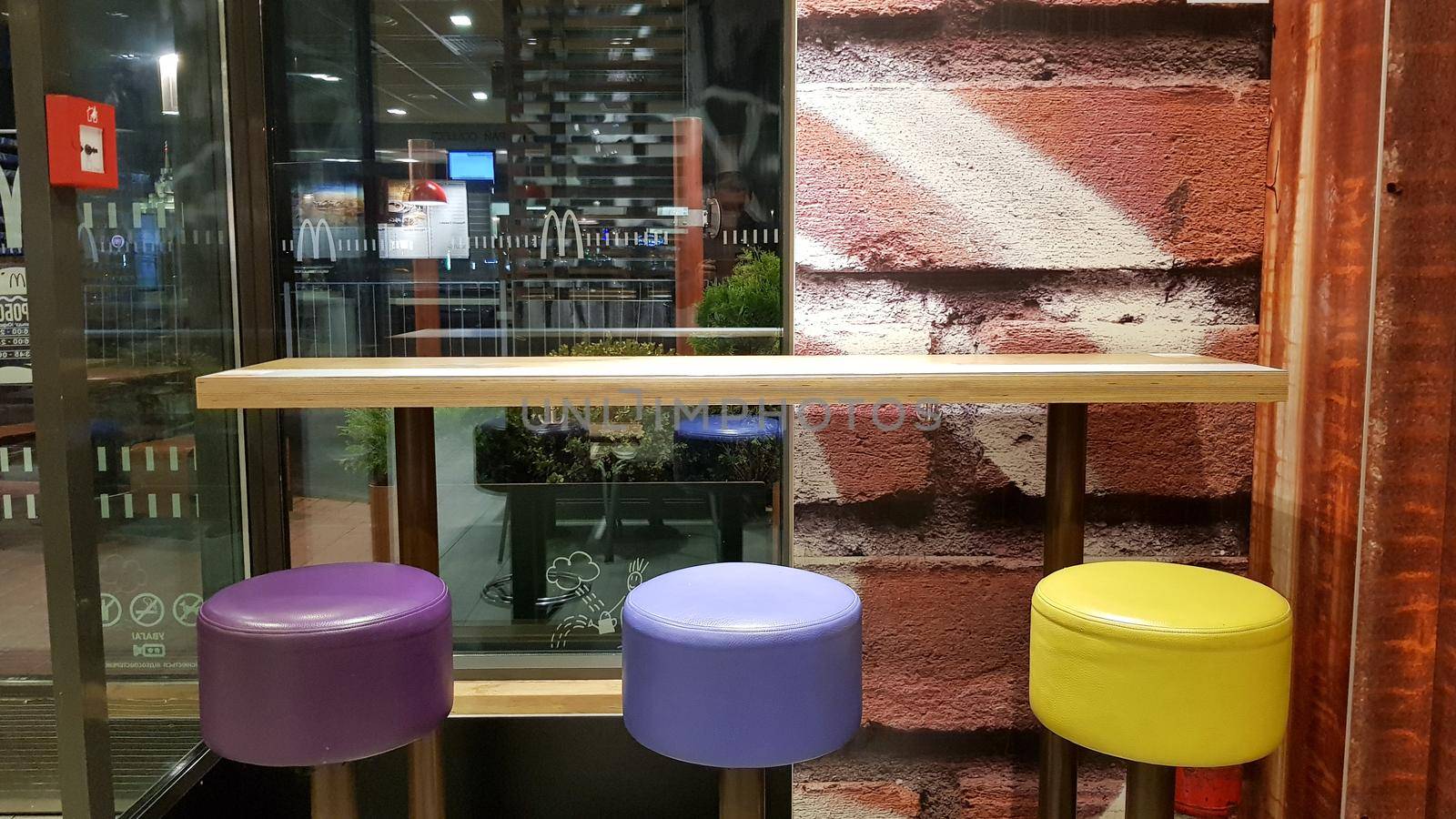 Ukraine, Kiev - August 19, 2019: McDonald's restaurant interior. McDonald's is the world's largest fast food restaurant chain based in the USA. Interior with tall tables and colored bar stools.