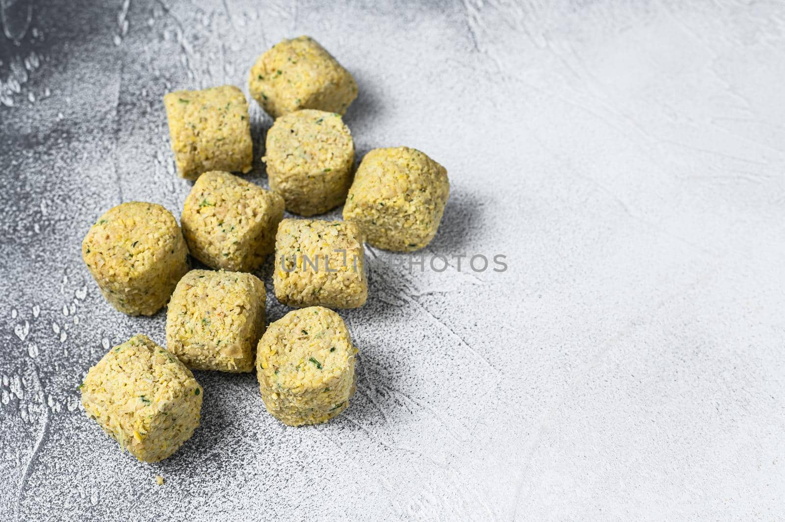 Raw falafel balls on a kitchen table. White background. Top view. Copy space by Composter