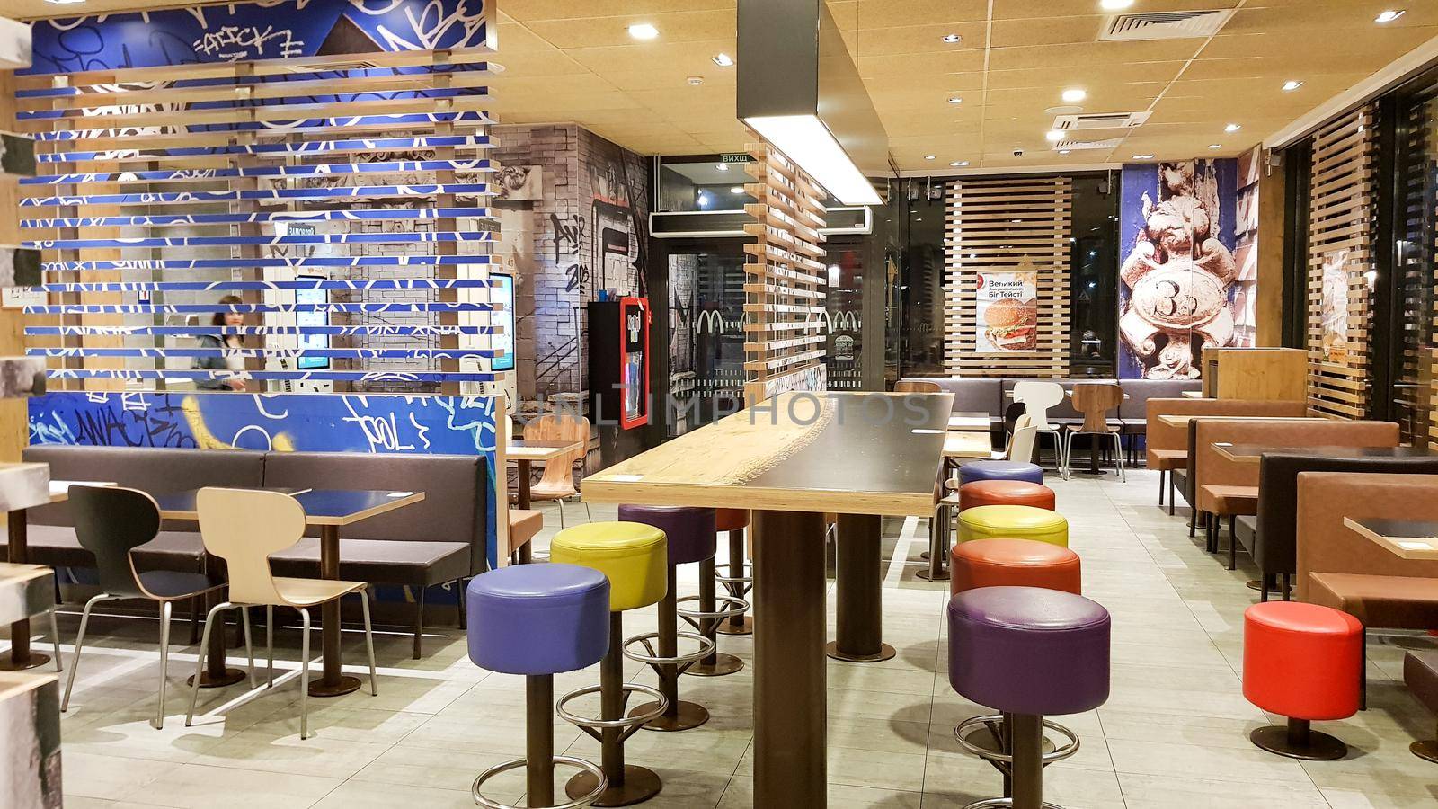 Ukraine, Kiev - August 19, 2019: McDonald's restaurant interior. McDonald's is the world's largest fast food restaurant chain based in the USA. Interior with tall tables and colored bar stools.