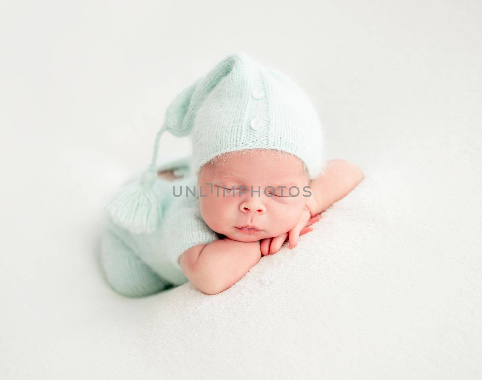 newborn baby girl sleeping sweetly in mint clothes