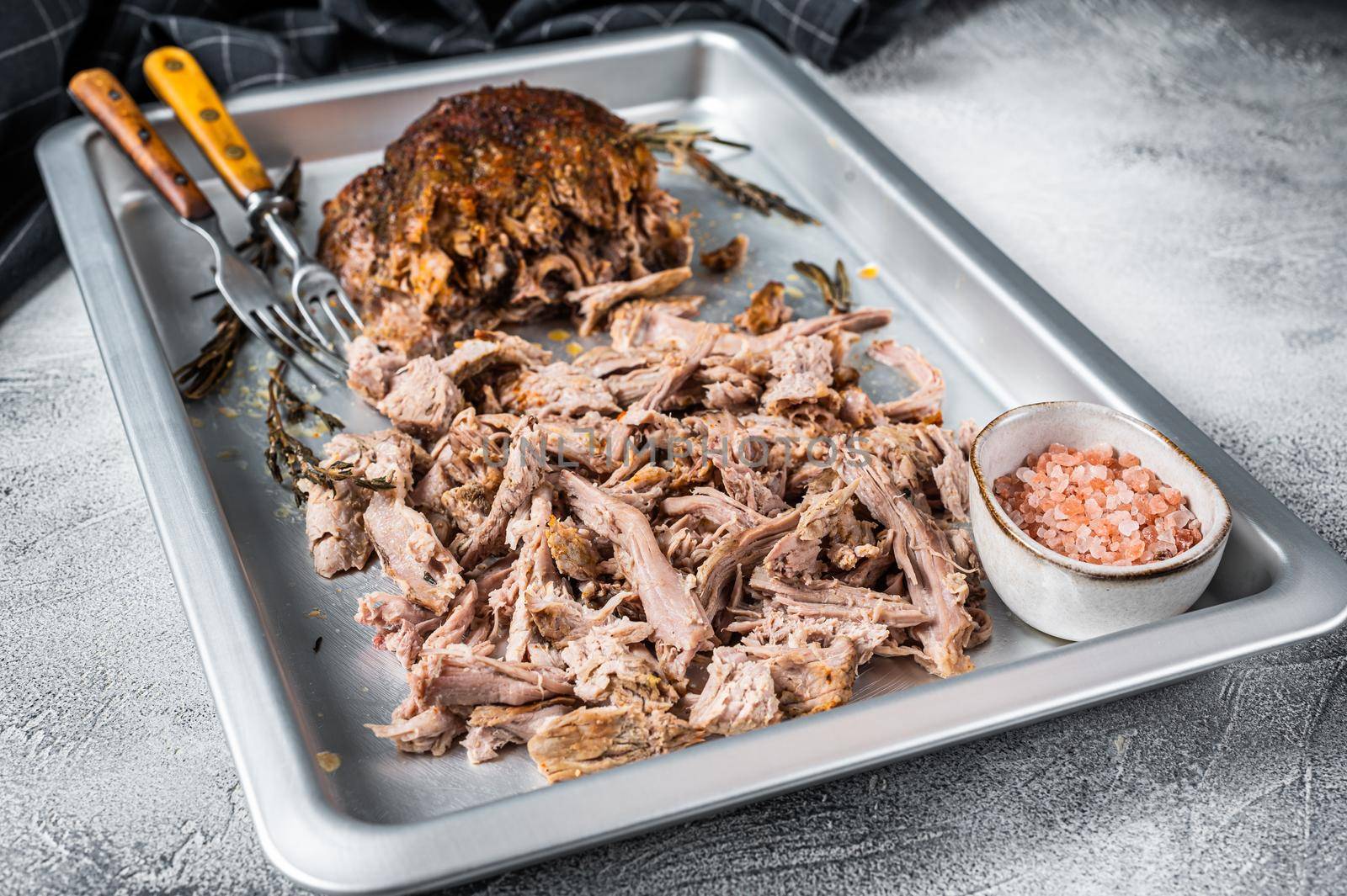 Bbq grilled puilled pork meat in a steel baking tray. White background. Top view.