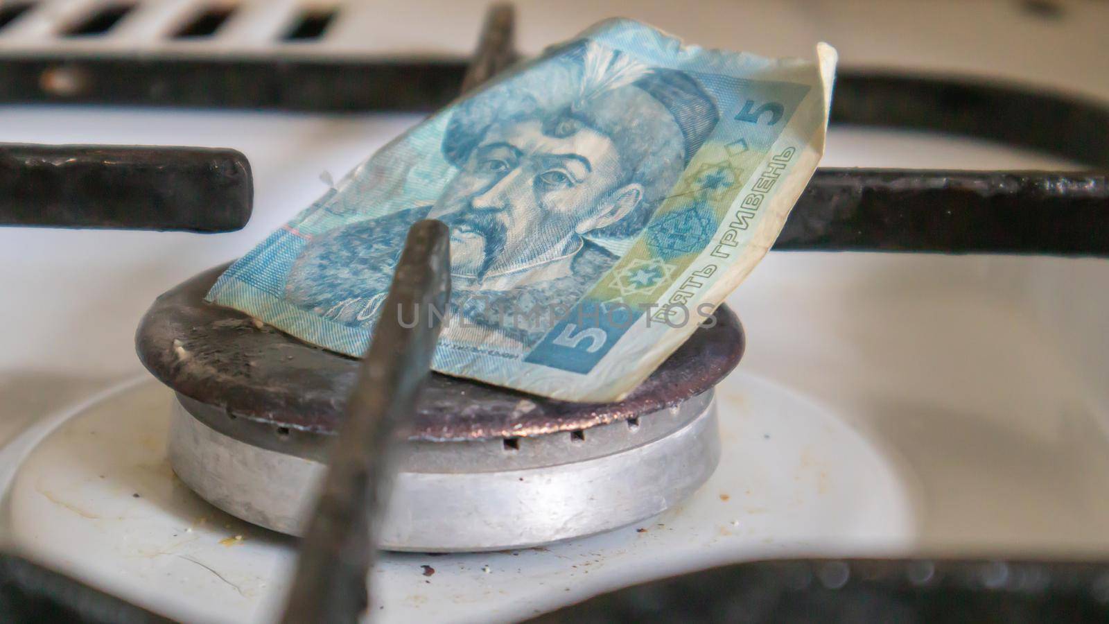 Ukrainian hryvnia on a gas water heater without fire. Gas stove with money. Conceptual image of a rising tariff for violence. Natural gas saving concept at home, high gas prices