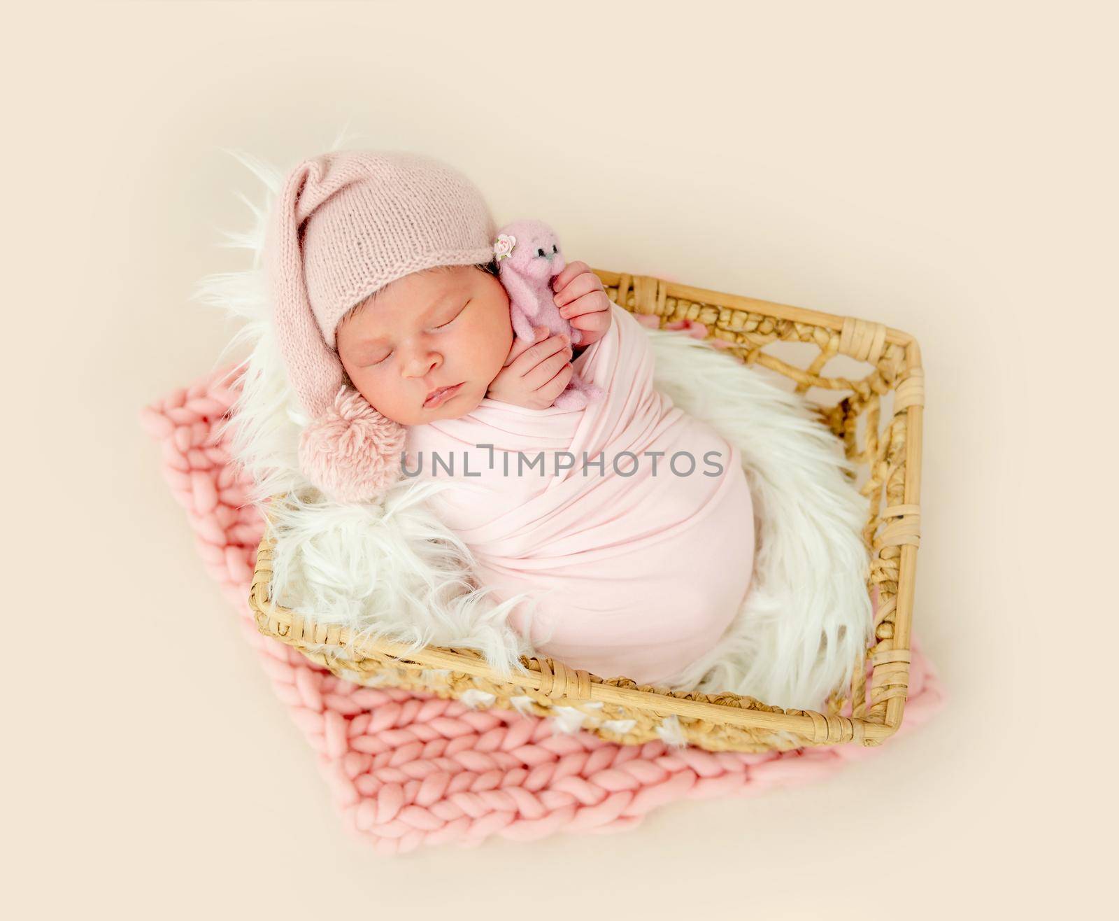 newborn baby girl sleeping sweetly with a small toy