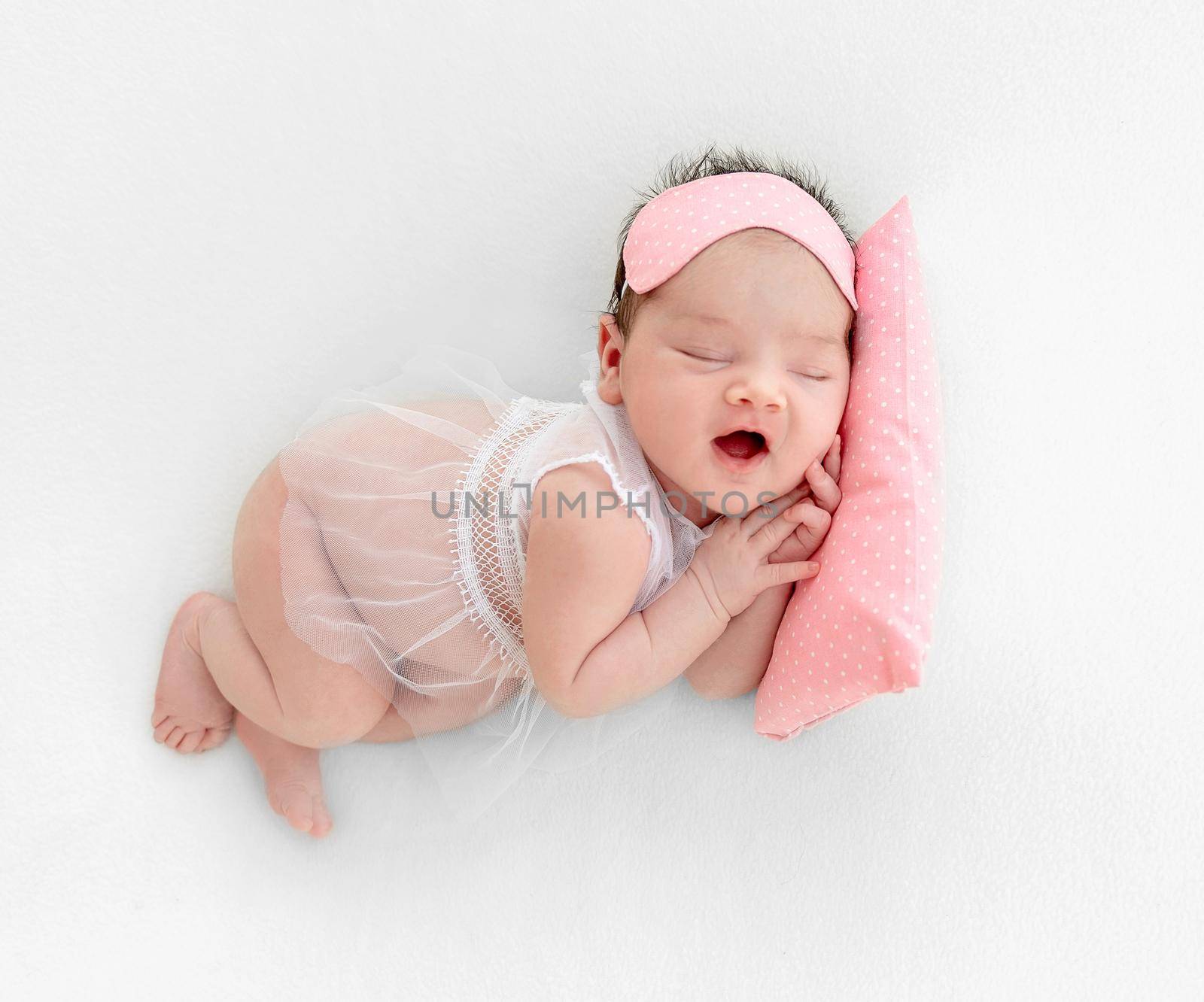 newborn baby girl sleeping sweetly on a little pillow