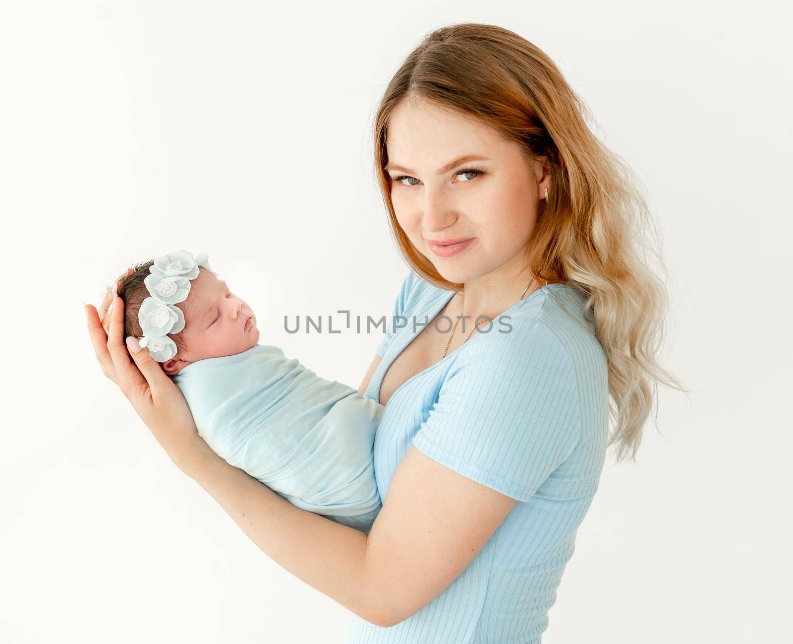 young beautiful mother holding a newborn daughter. white background