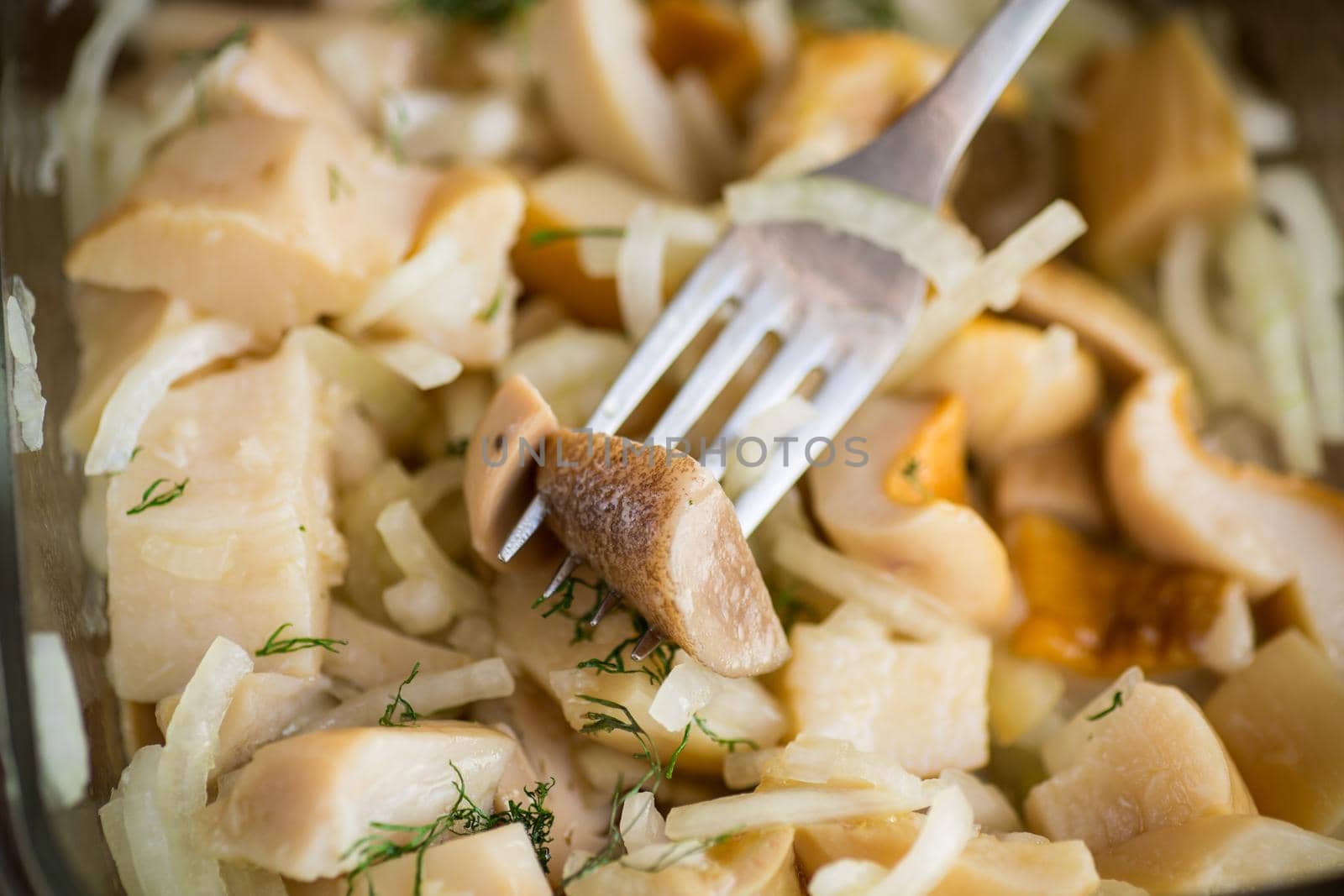 natural organic wild mushrooms marinated with onions in a glass bowl on the table