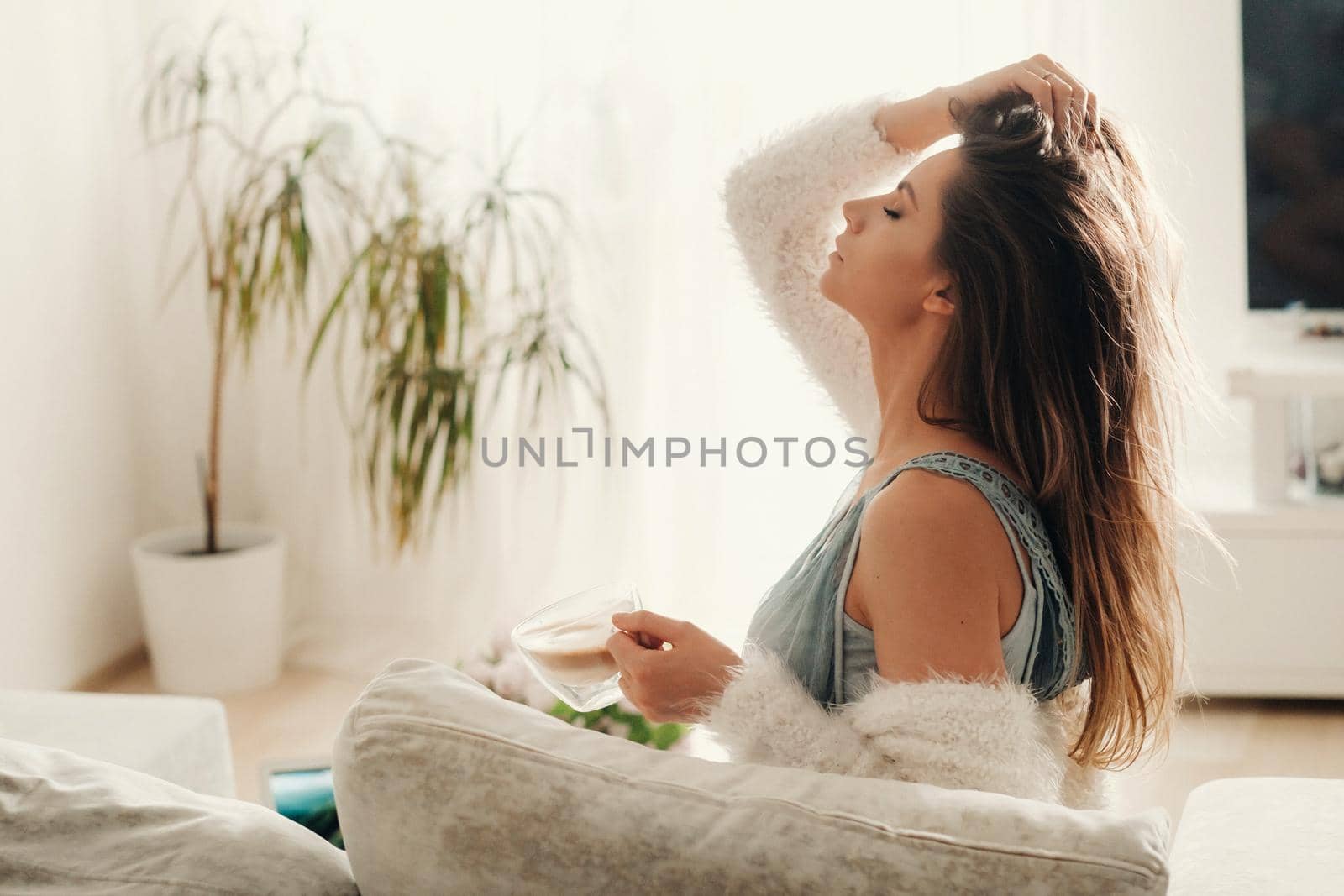 relaxed girl at home drinking coffee.Inner peace.The girl is sitting comfortably on the sofa and drinking coffee.