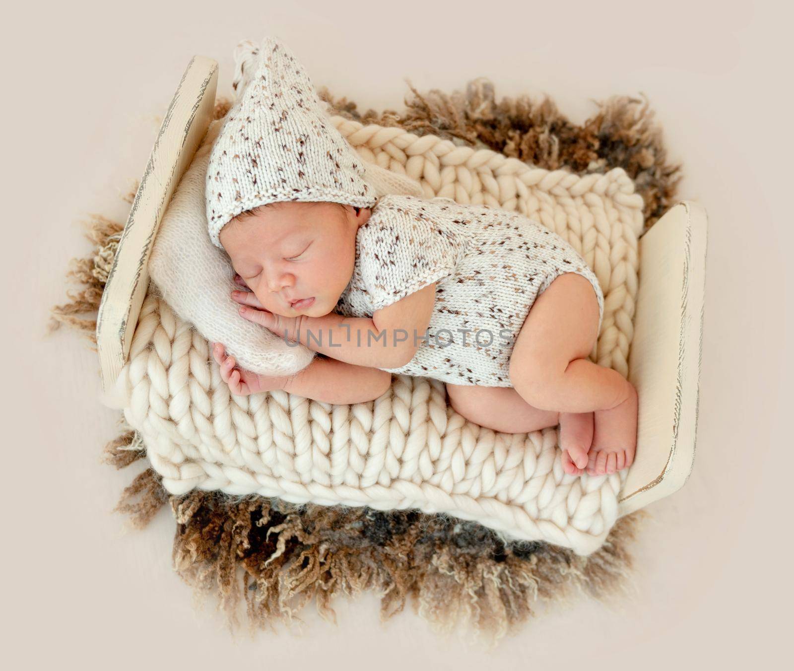 Dreamy newborn baby sleeping peacefully on the side on bed