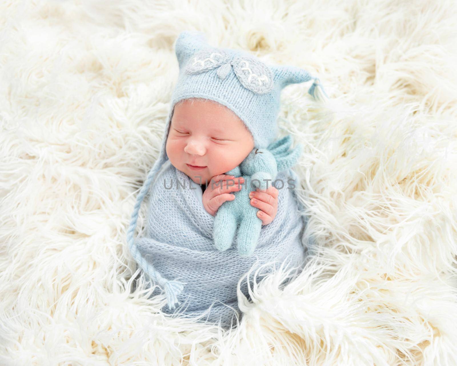 Cute newborn in blue knitted suit