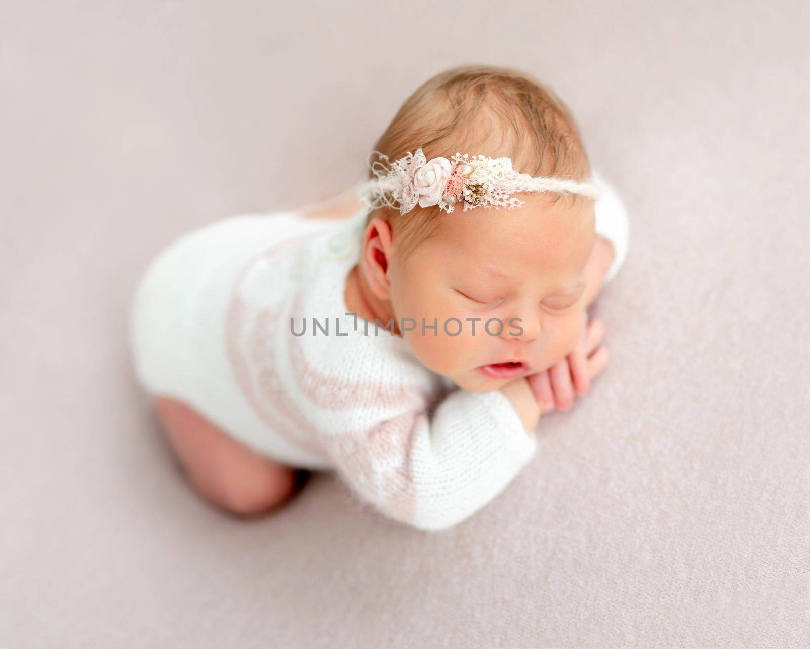 Beautiful newborn baby in floral diadem dreaming