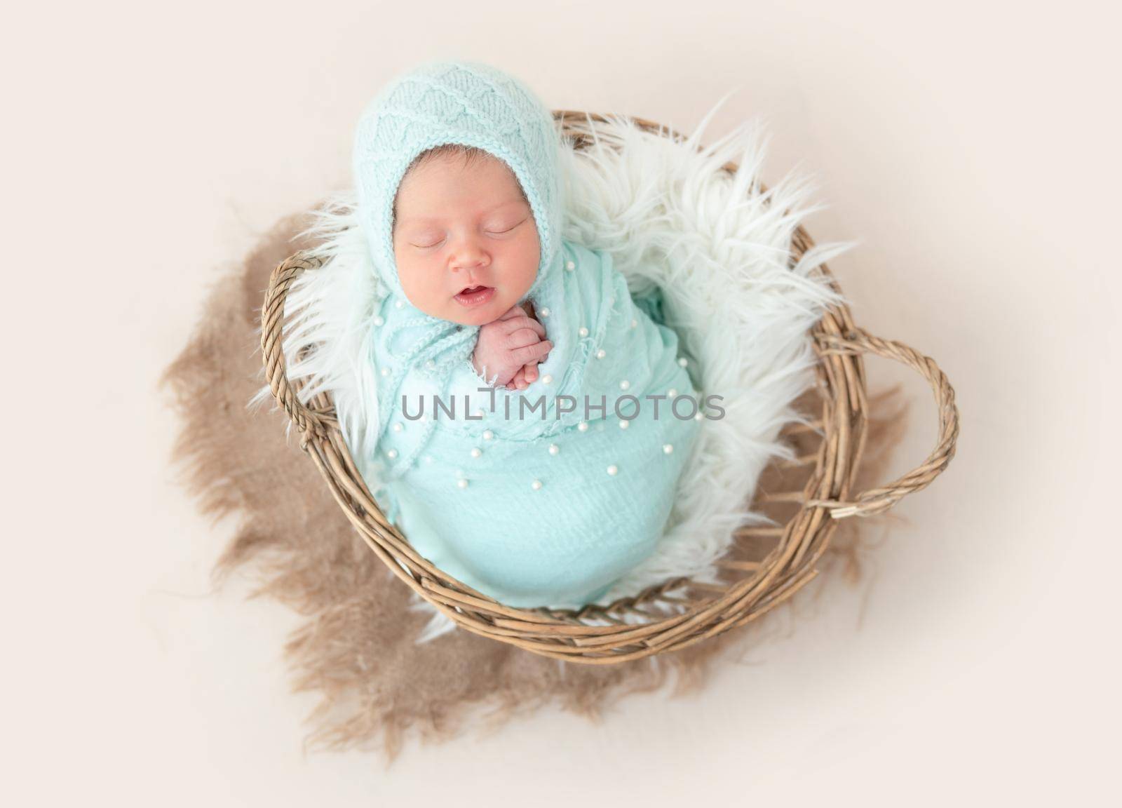 Adorable wrapped up newborn lying in basket