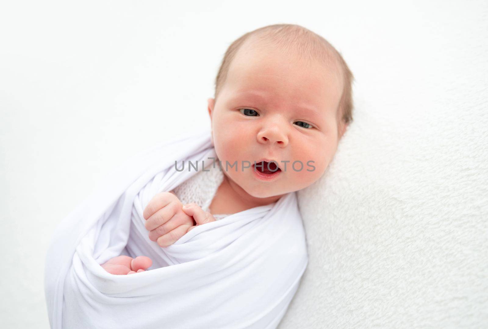 Beautiful awaken newborn wrapped in blanket