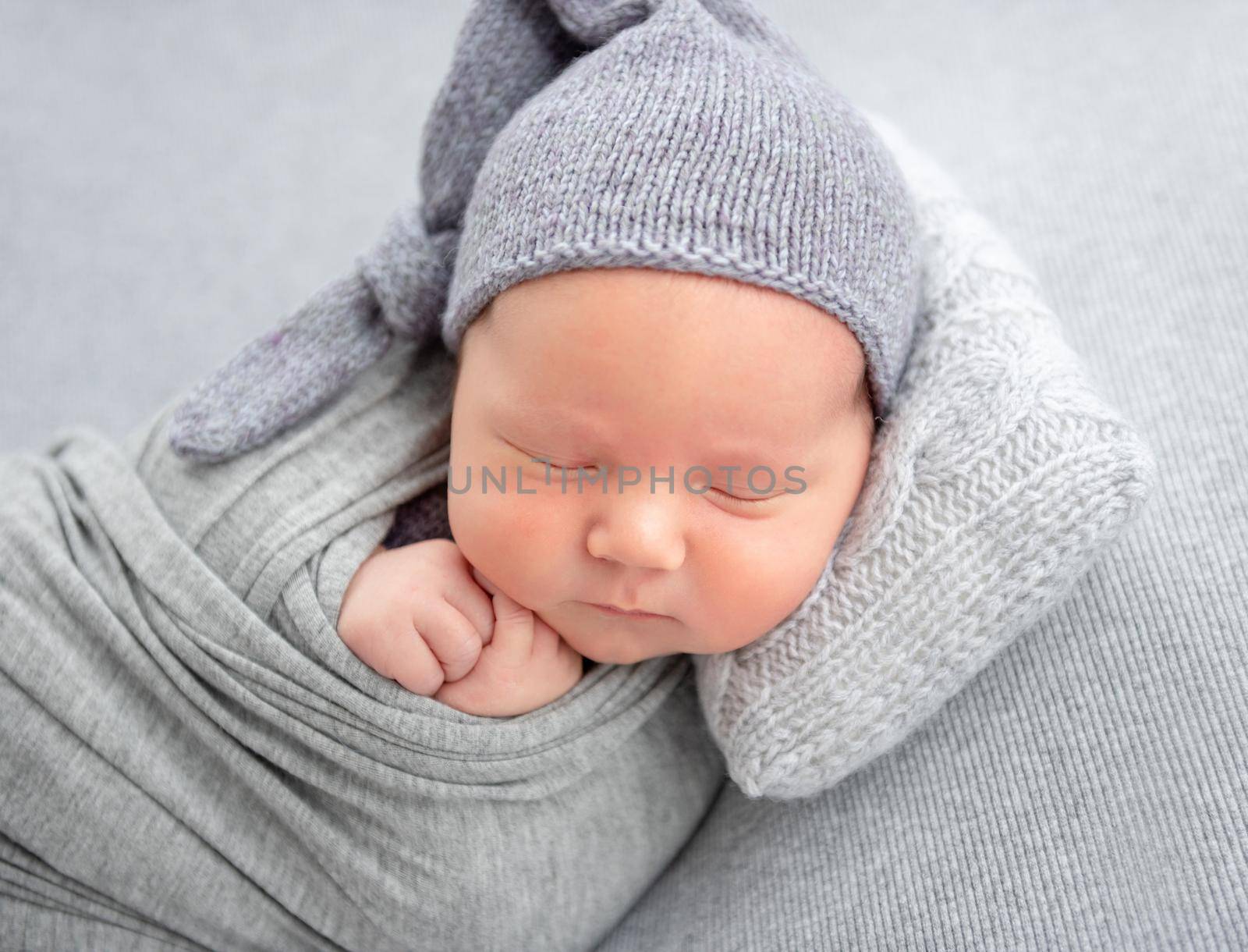 Adorable newborn resting on tiny pillow