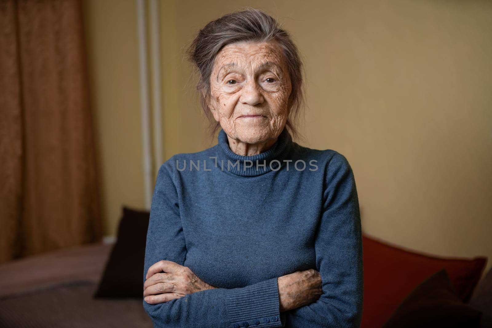 Elderly Caucasian senior grandmother ninety years old looks attentively and smiles, feels happy, large portrait, face with deep wrinkles, gray hair. Theme pensioners, old people and long-lived woman by Tomashevska