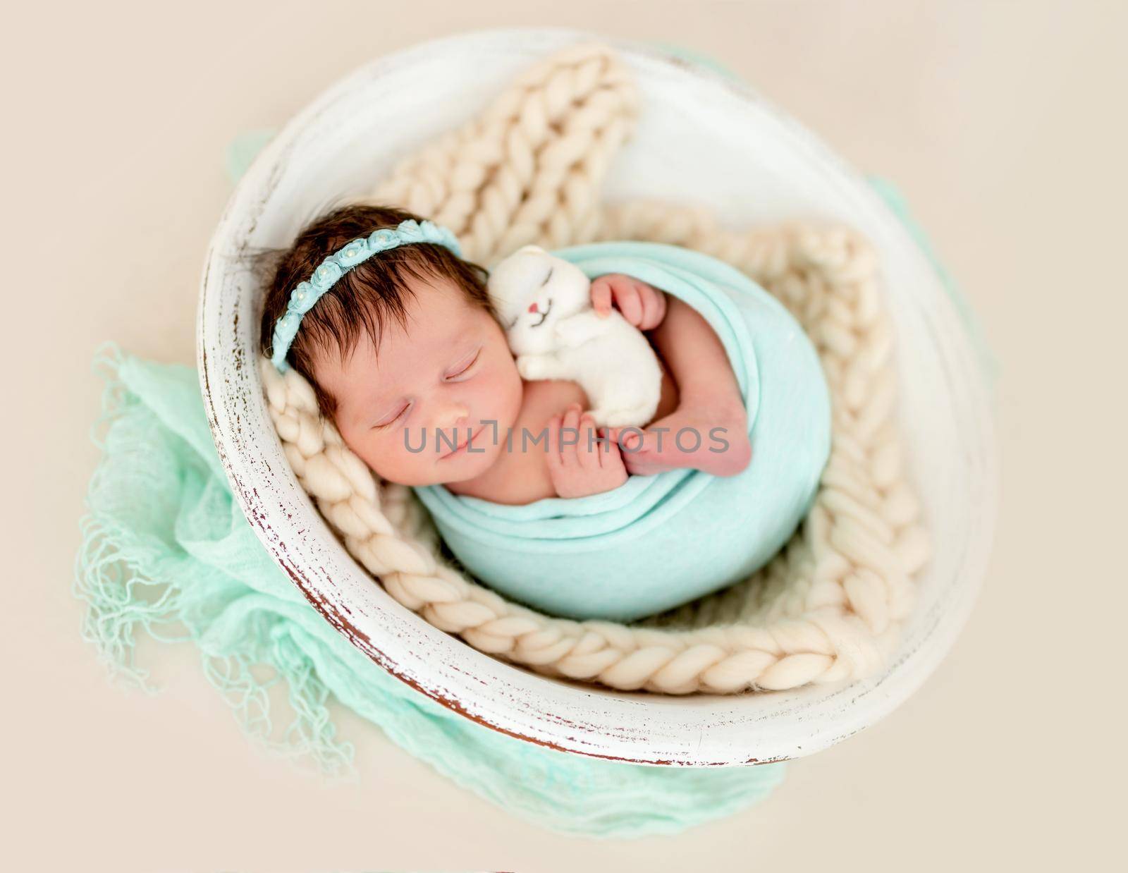 Smiling newborn girl sleeping in cradle