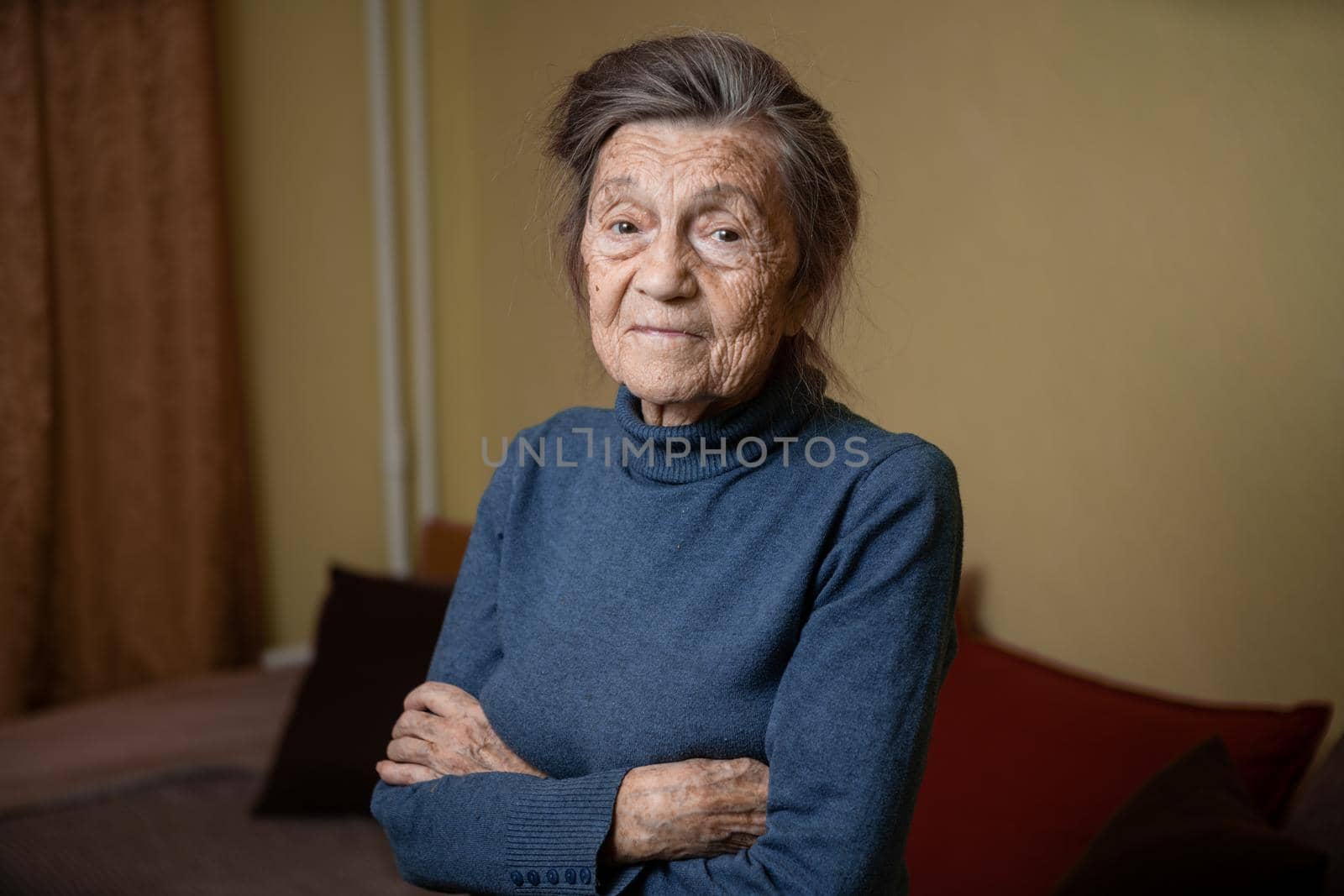Elderly Caucasian senior grandmother ninety years old looks attentively and smiles, feels happy, large portrait, face with deep wrinkles, gray hair. Theme pensioners, old people and long-lived woman by Tomashevska