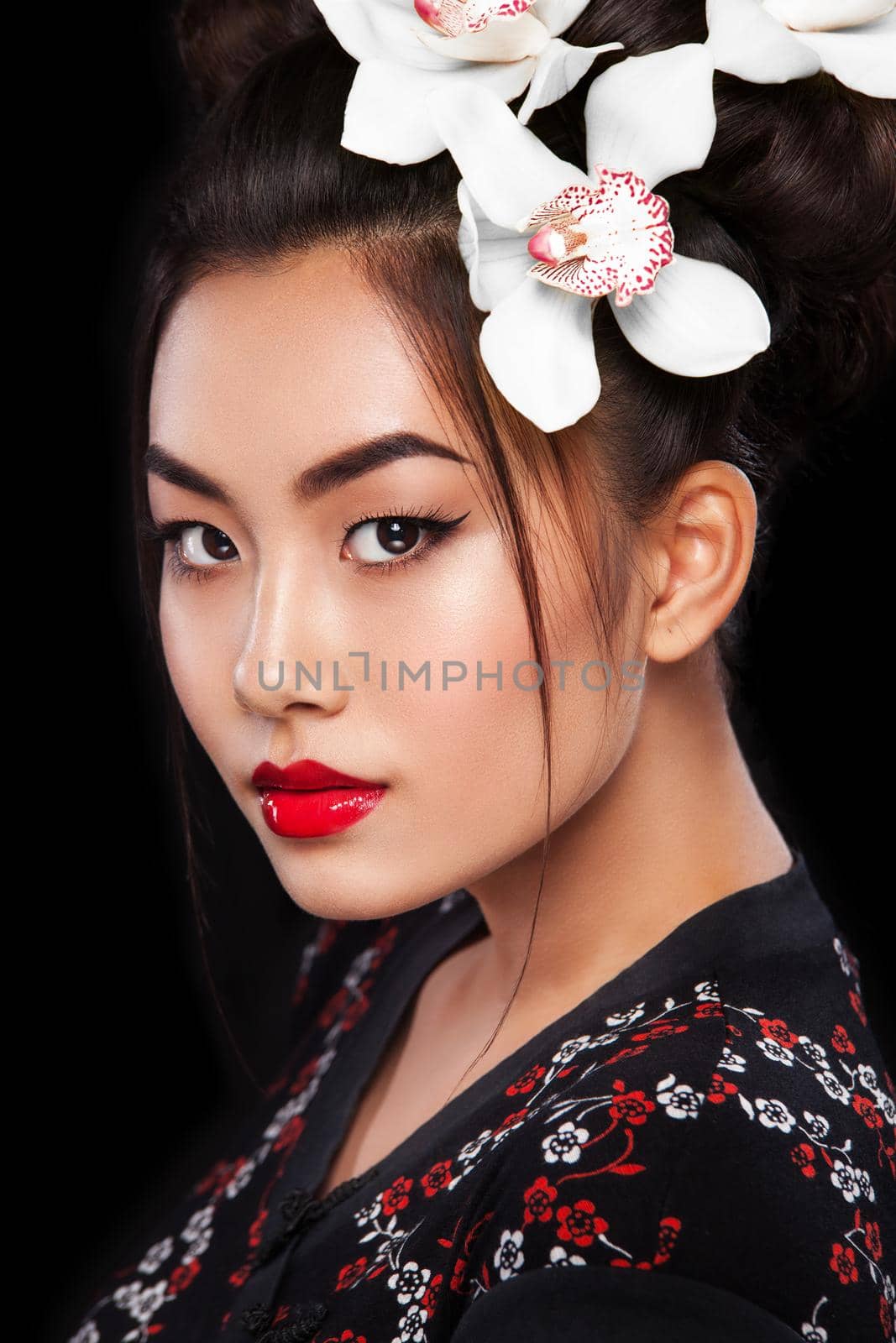 Studio fashion shot of Asian woman with white flower in hair by MikeOrlov