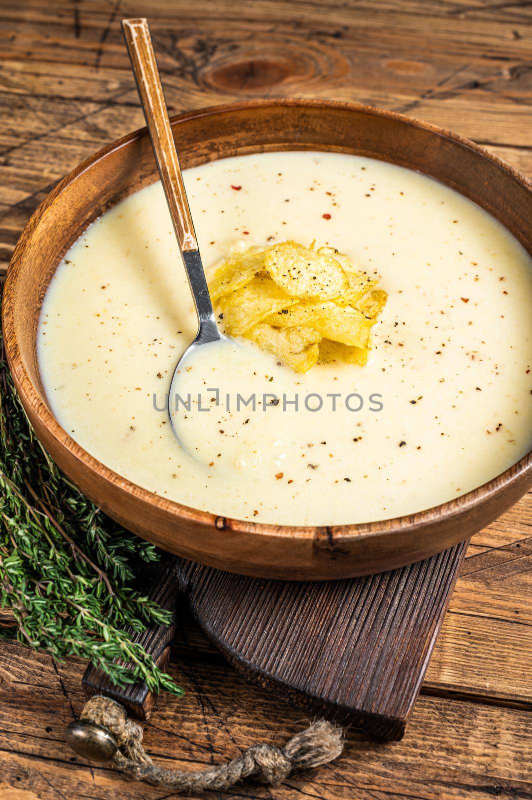 Cream potato soup with potato chips in wooden plate. wooden background. Top view by Composter