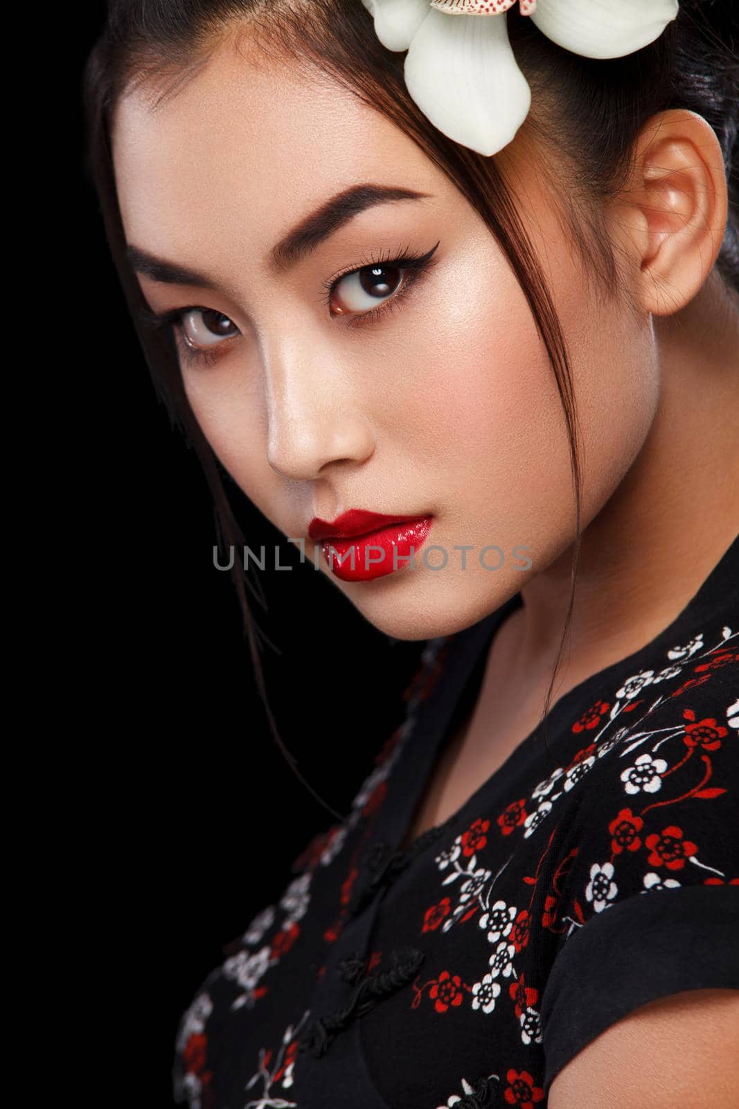 Studio fashion shot of Asian woman with white flower in hair by MikeOrlov