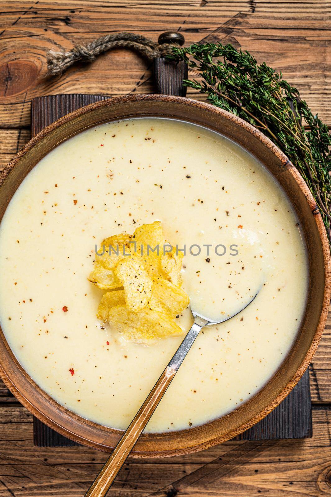 Cream potato soup with potato chips in wooden plate. wooden background. Top view by Composter