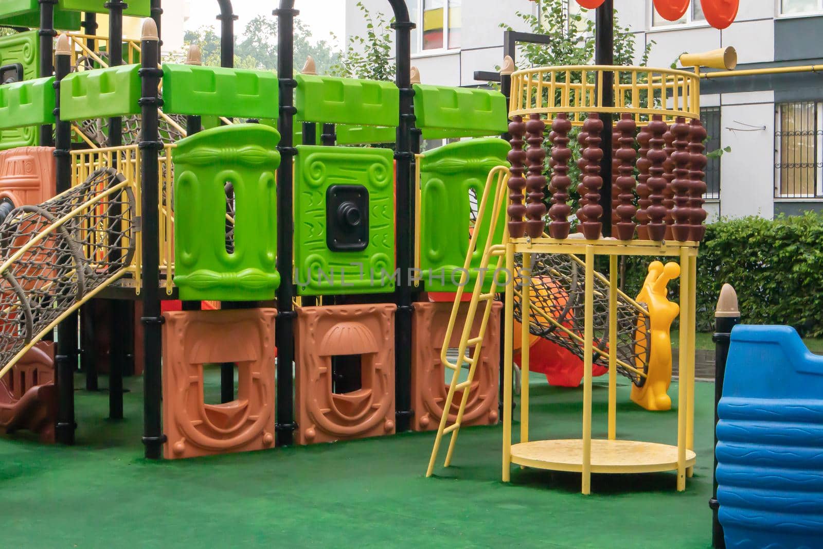 The courtyard of a high-rise building with a modern large playground made of wood and plastic on a rainy summer day without people. Ukraine, Kiev - August 19, 2021