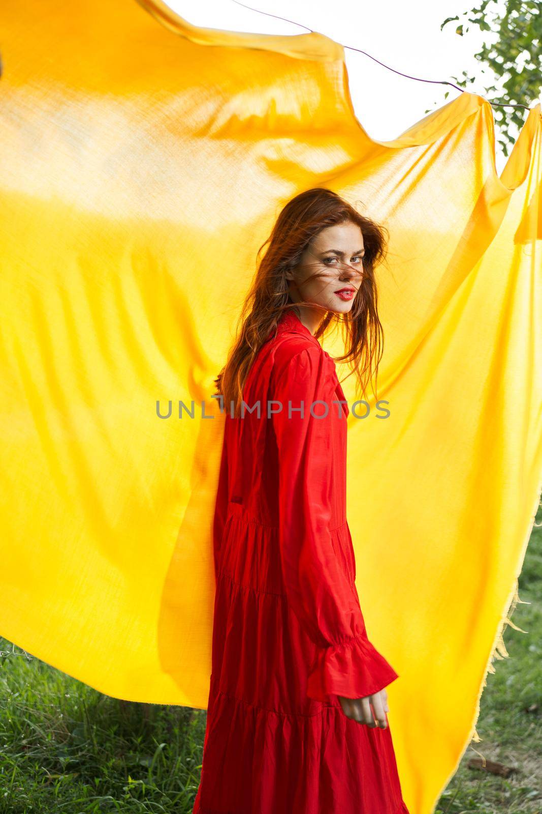 smiling woman in red dress posing yellow background by Vichizh