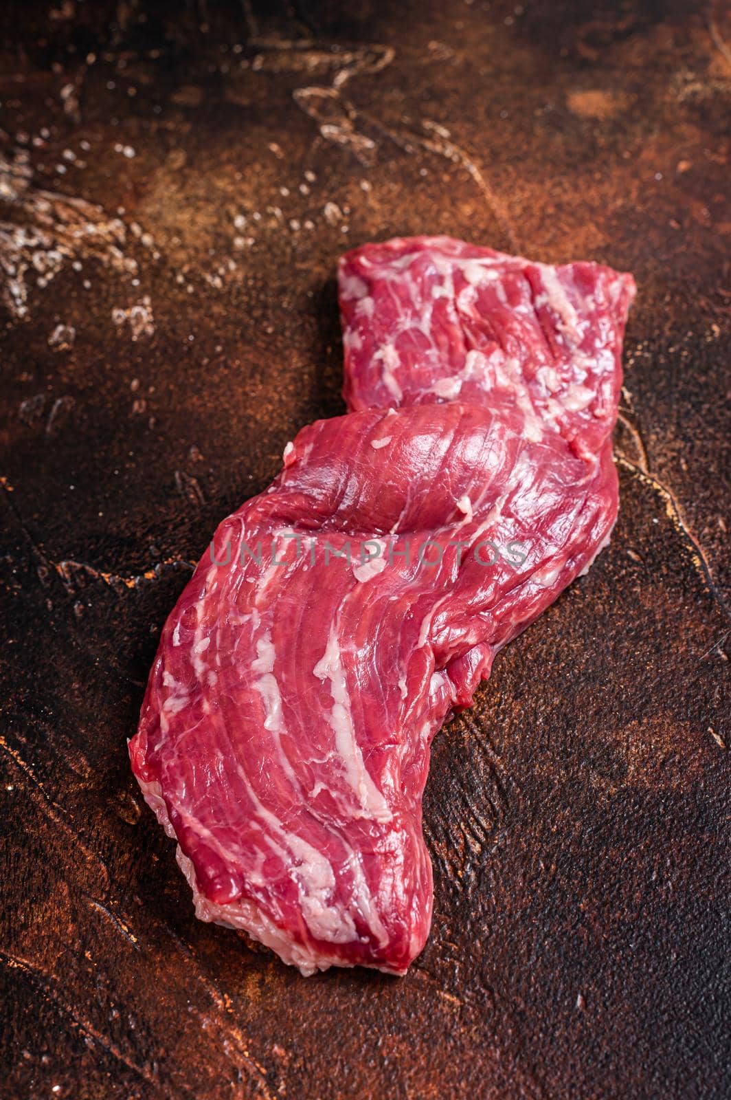 Raw machete skirt beef steak on butcher table. Dark background. Top view by Composter