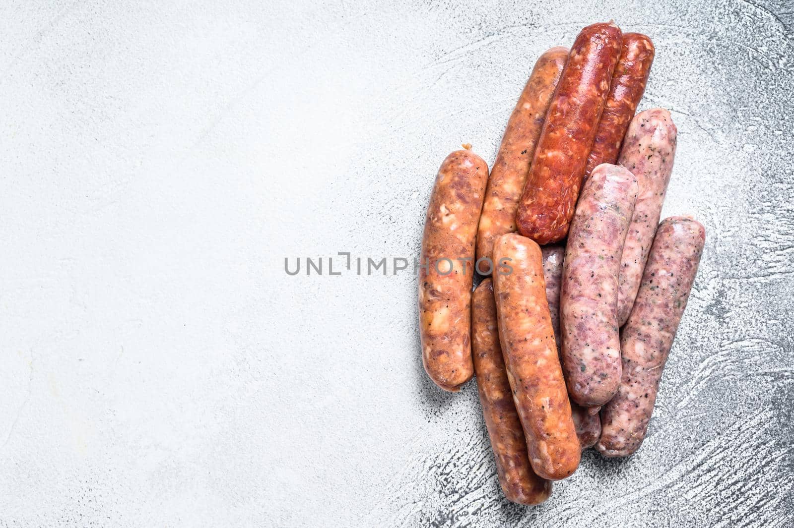 Assorted raw chorizo sausages. White background. Top view. Copy space.