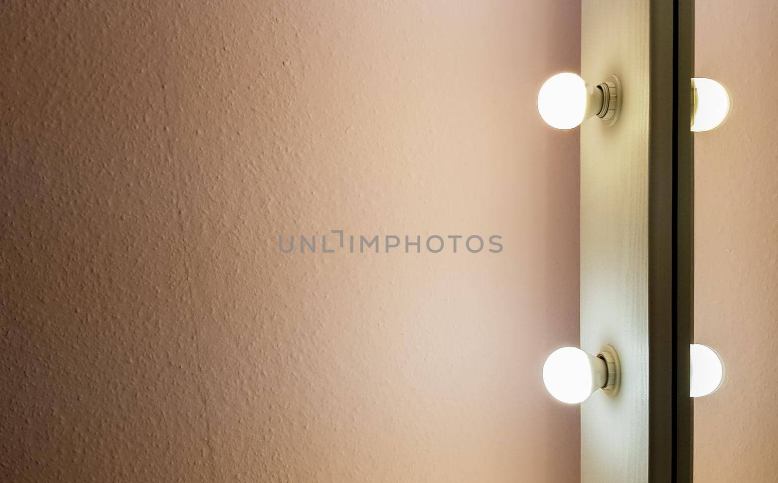 Modern new flat pink wall with two light bulbs from a large floor mirror for makeup and full-length shopping. Abstract modern trendy texture background. Copy space for your text