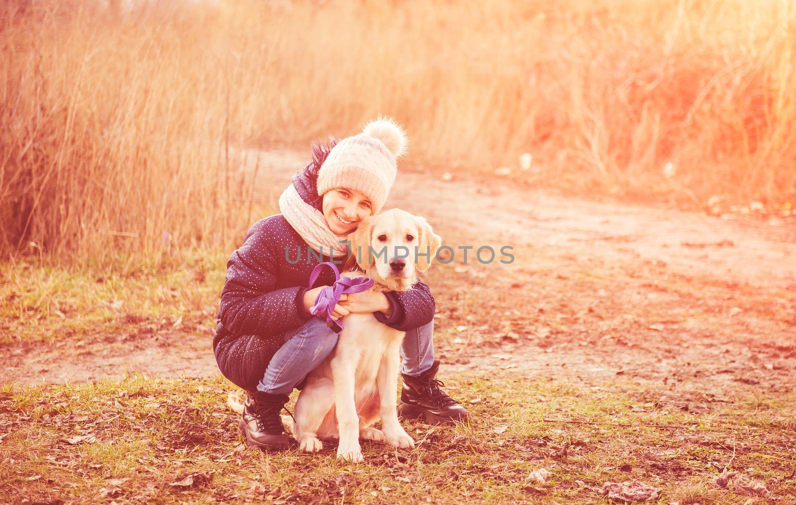 Cute girl with young dog in autumn park