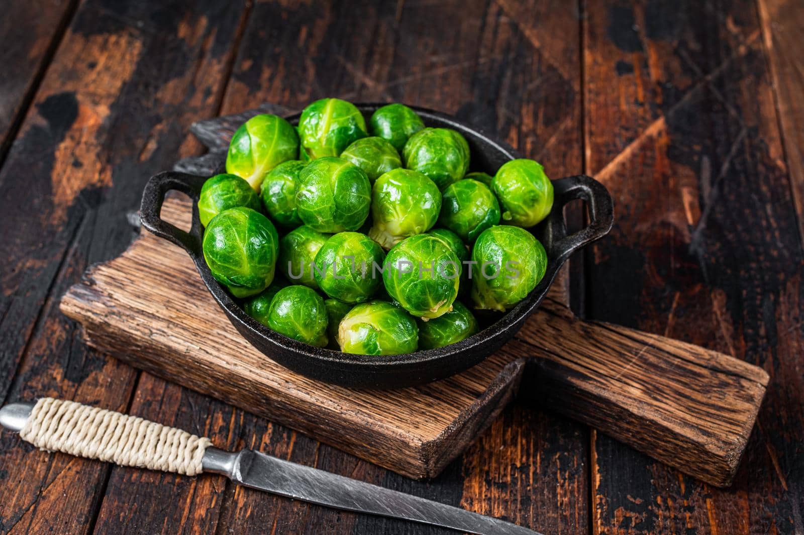 Boiled Brussels green sprouts cabbage in a pan. Dark wooden background. Top view by Composter