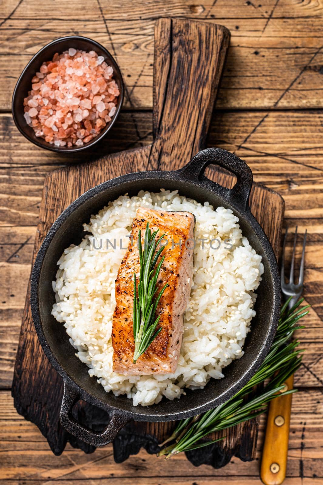 Grilled Salmon Fillet Steaks with white rice in a pan. wooden background. Top view by Composter