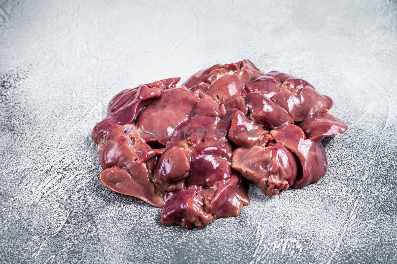 Raw chicken liver meat on butcher table. White background. Top view.