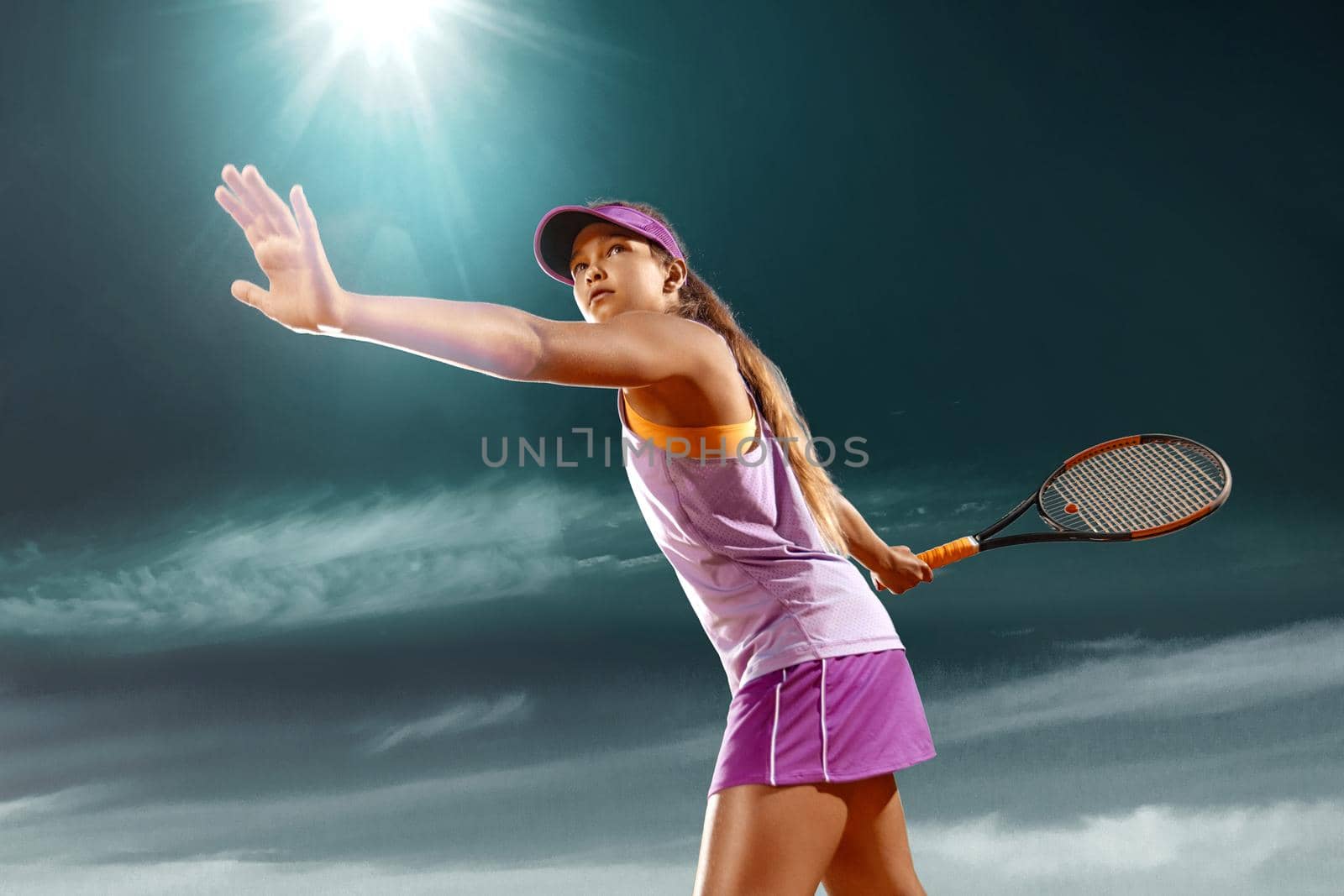 Beautiful girl tennis player with a racket on dark background wiht lights