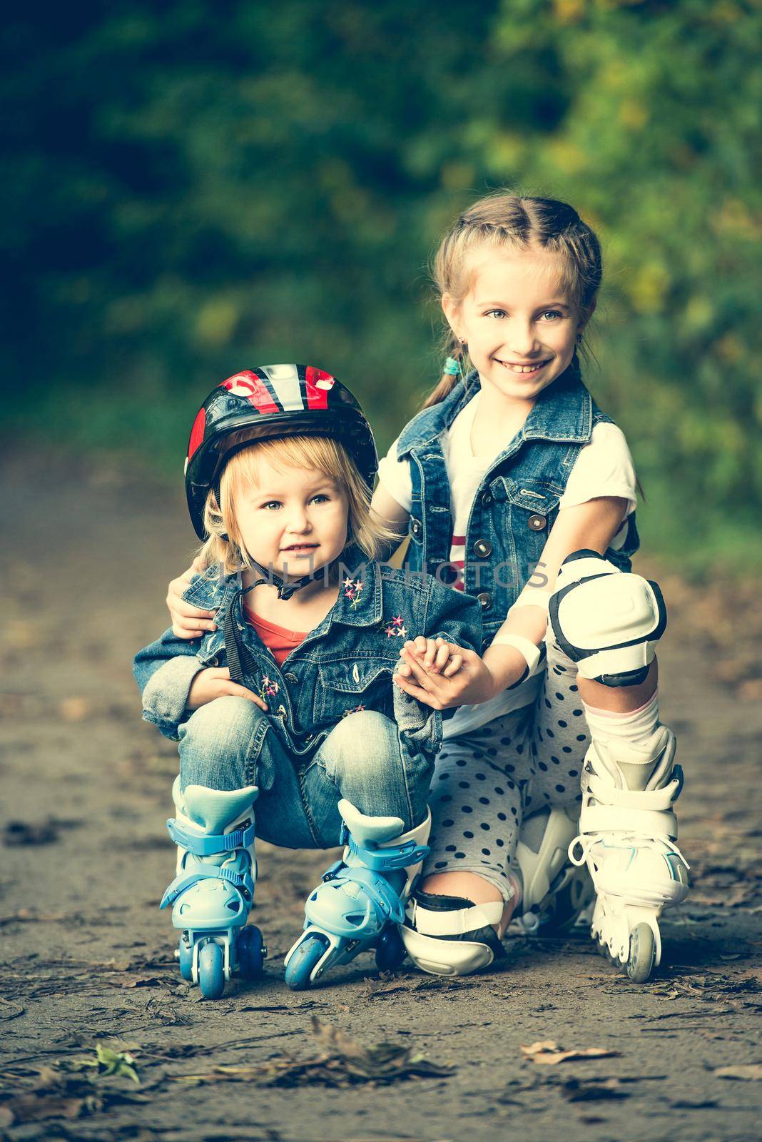 two sisters on roller skates in park