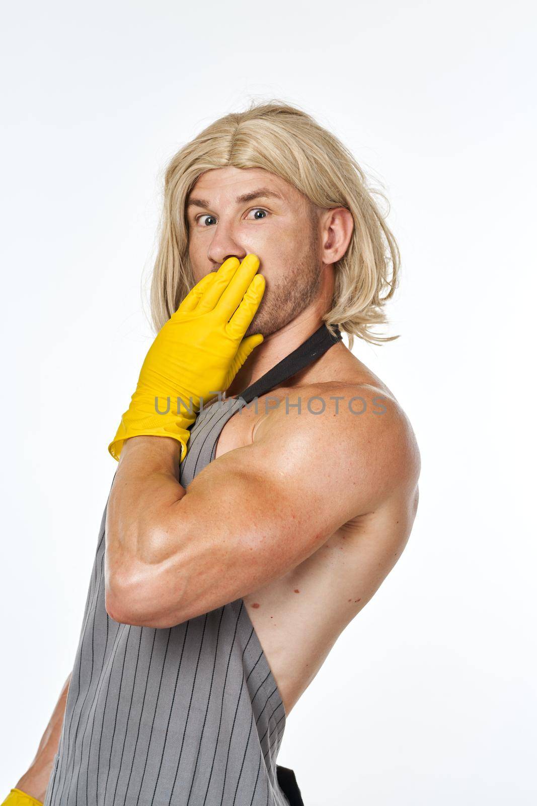 man in yellow rubber gloves in a woman's wig cleaning posing. High quality photo