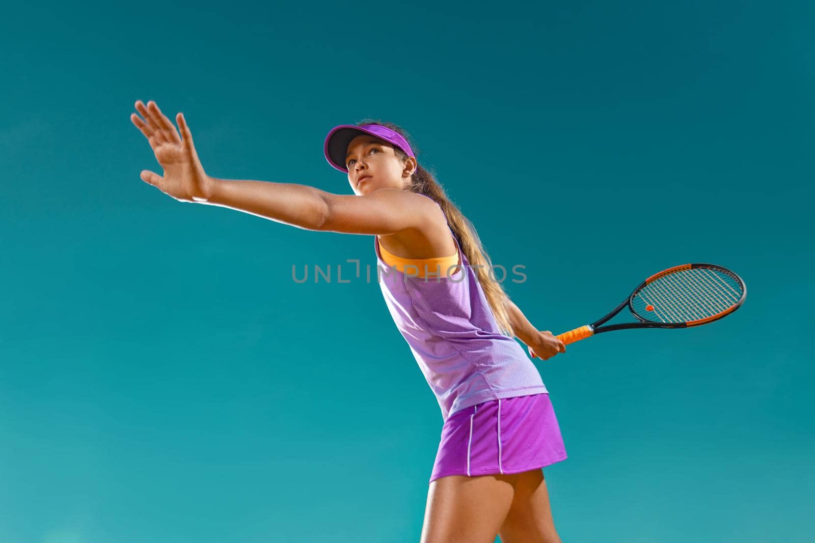 Teenager tennis player. Beautiful girl athlete with racket in pink sporswear and hat on tennis court. Fashion and sport concept. by MikeOrlov