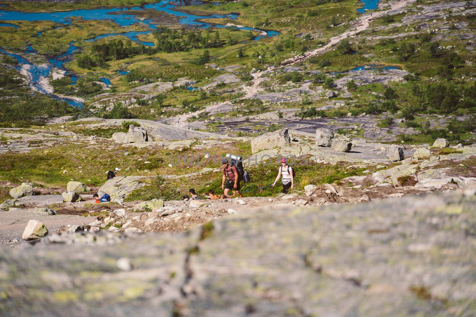 July 26, 2019. Norway tourist route on the trolltunga. People tourists go hiking in the mountains of Norway in fine sunny weather to thetrolltunga. Hiking backpack theme by Tomashevska